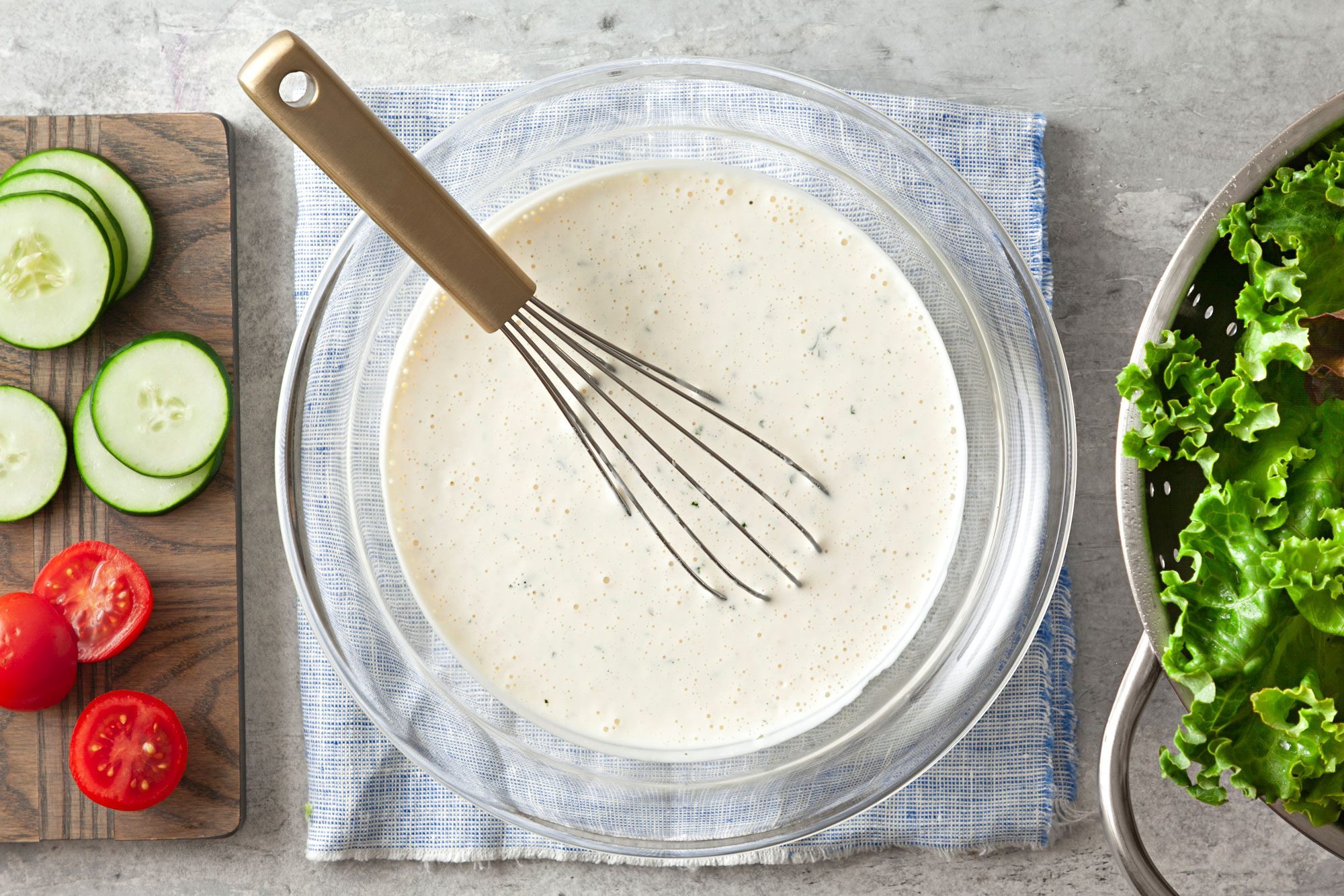 Basic Buttermilk Salad Dressing in a large glass bowl over kitchen towel with whisker