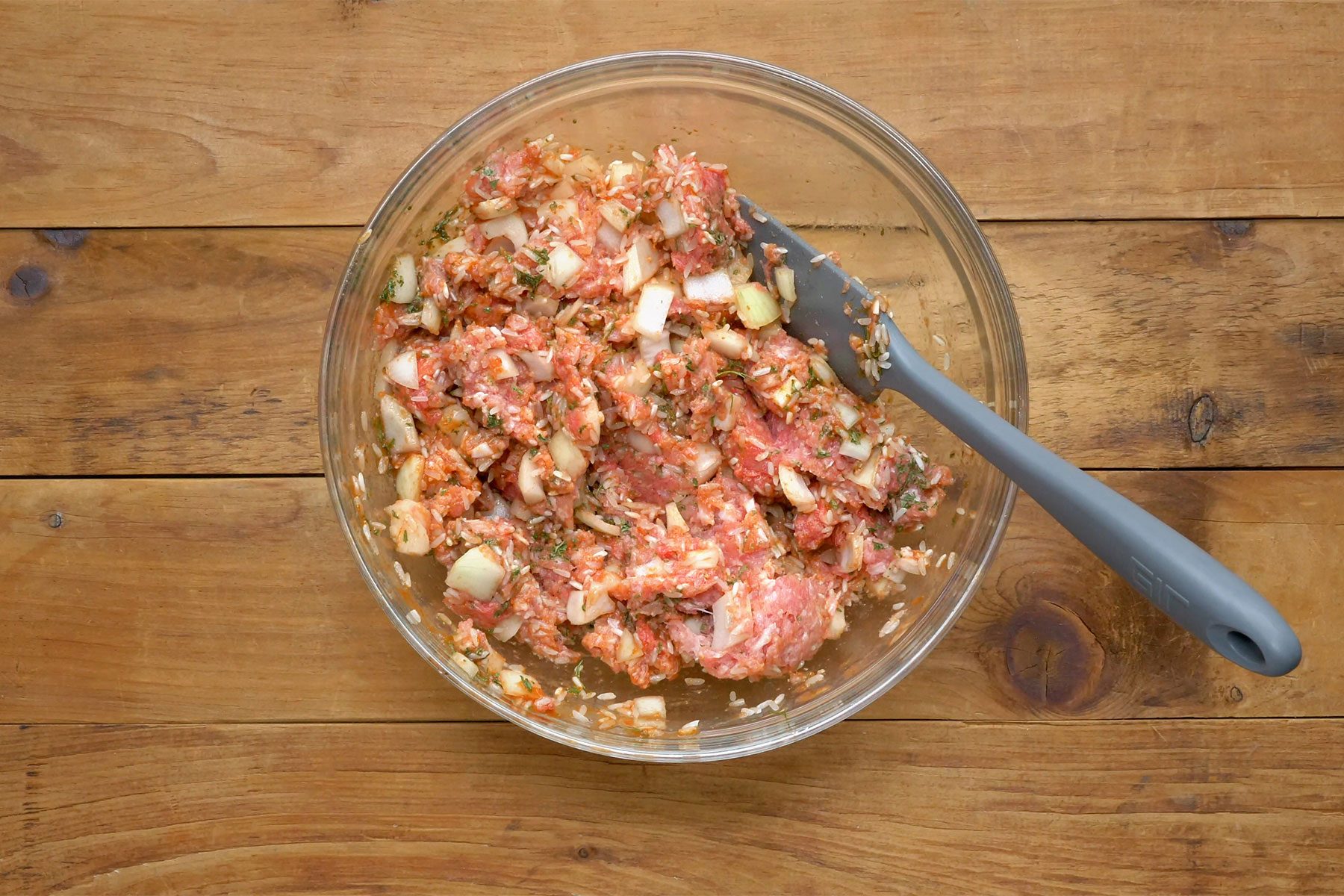 overhead shot of meat mixture in a large bowl with spatula