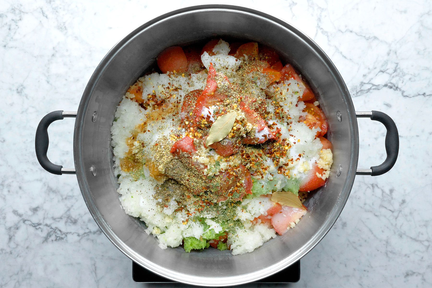 Overheda shot of placed ingredients in stockpot; marble background;