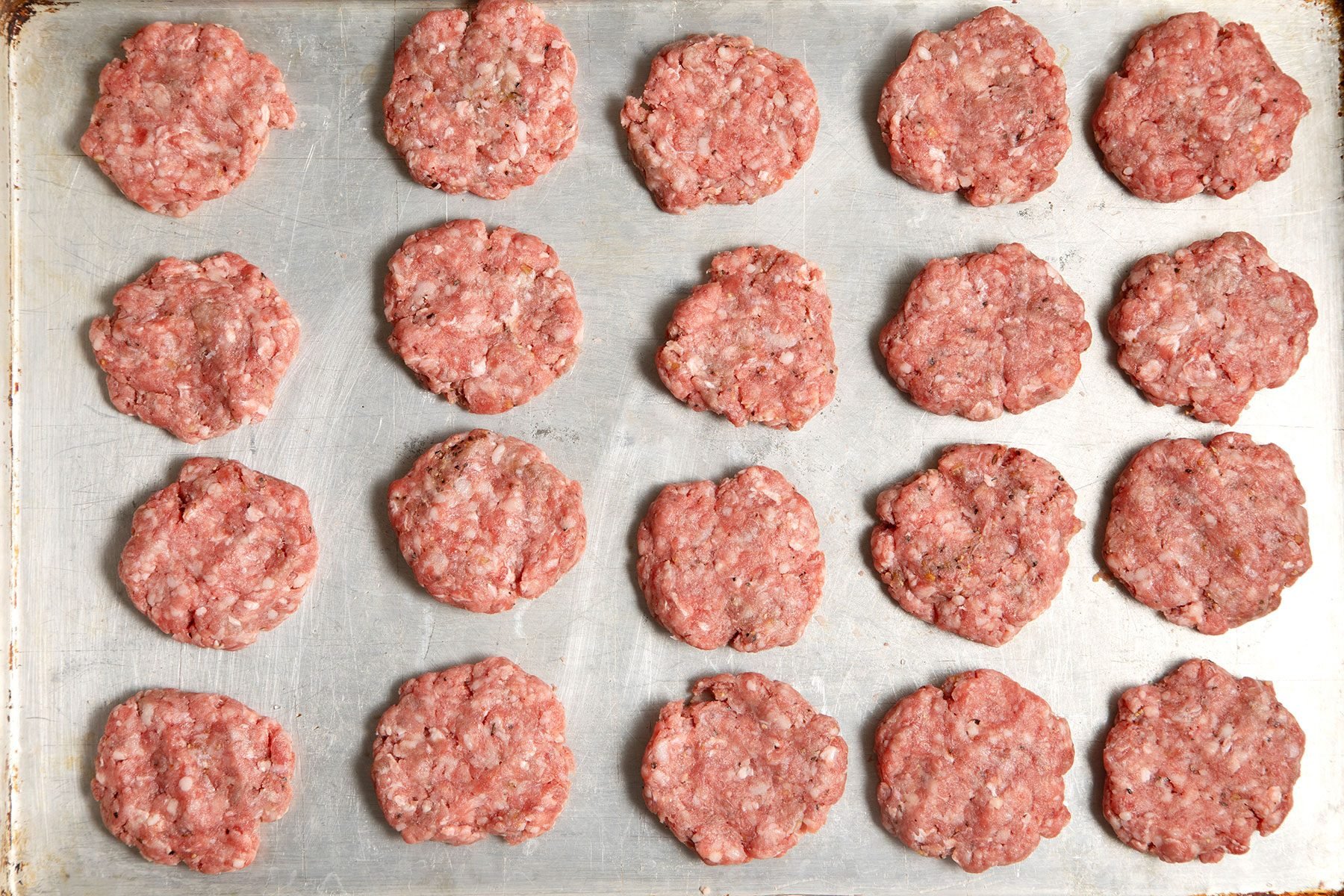 overhead shot; burger patties placed over dish;