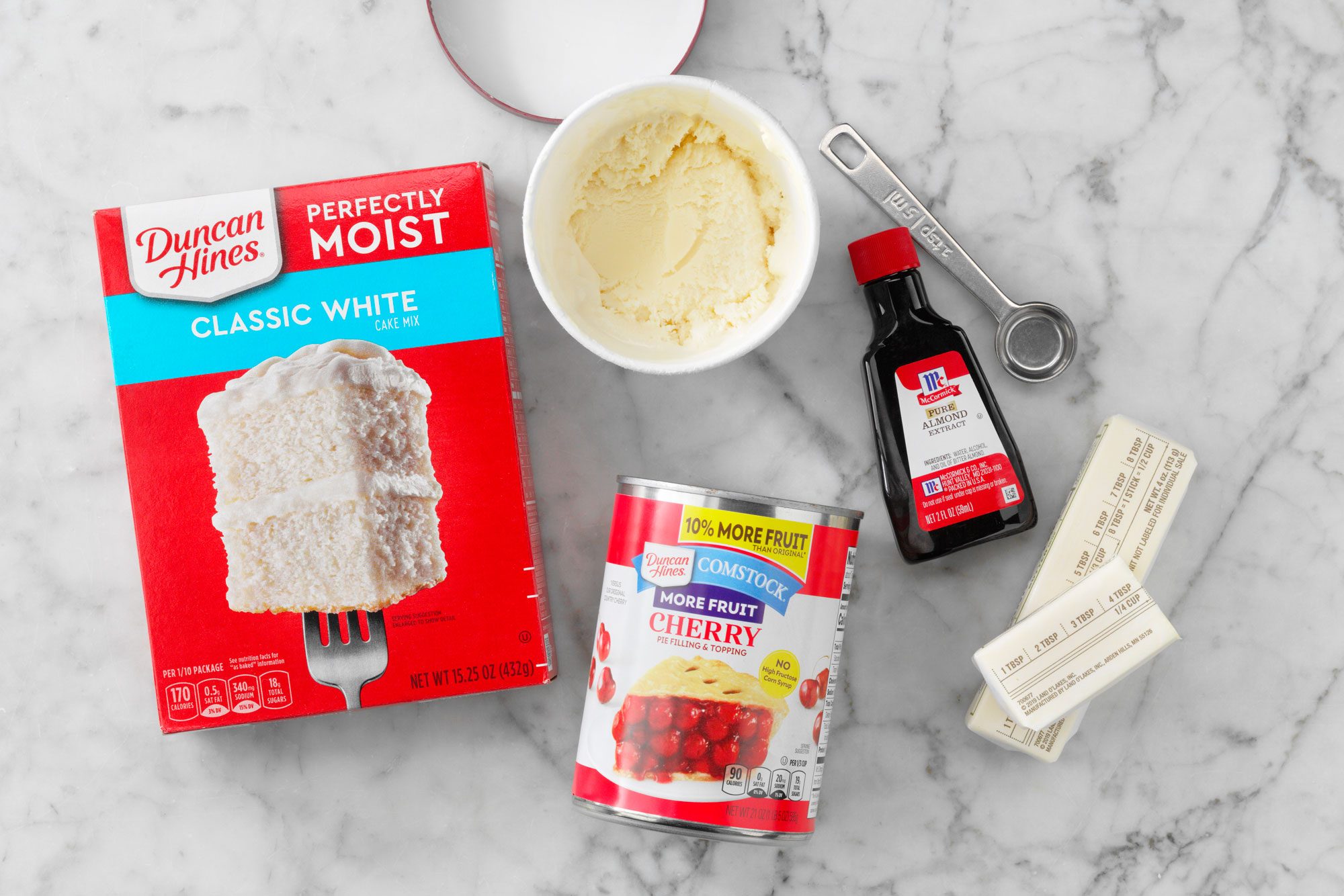 overhead shot of all ingredients for Cherry Dump Cake on the marble surface