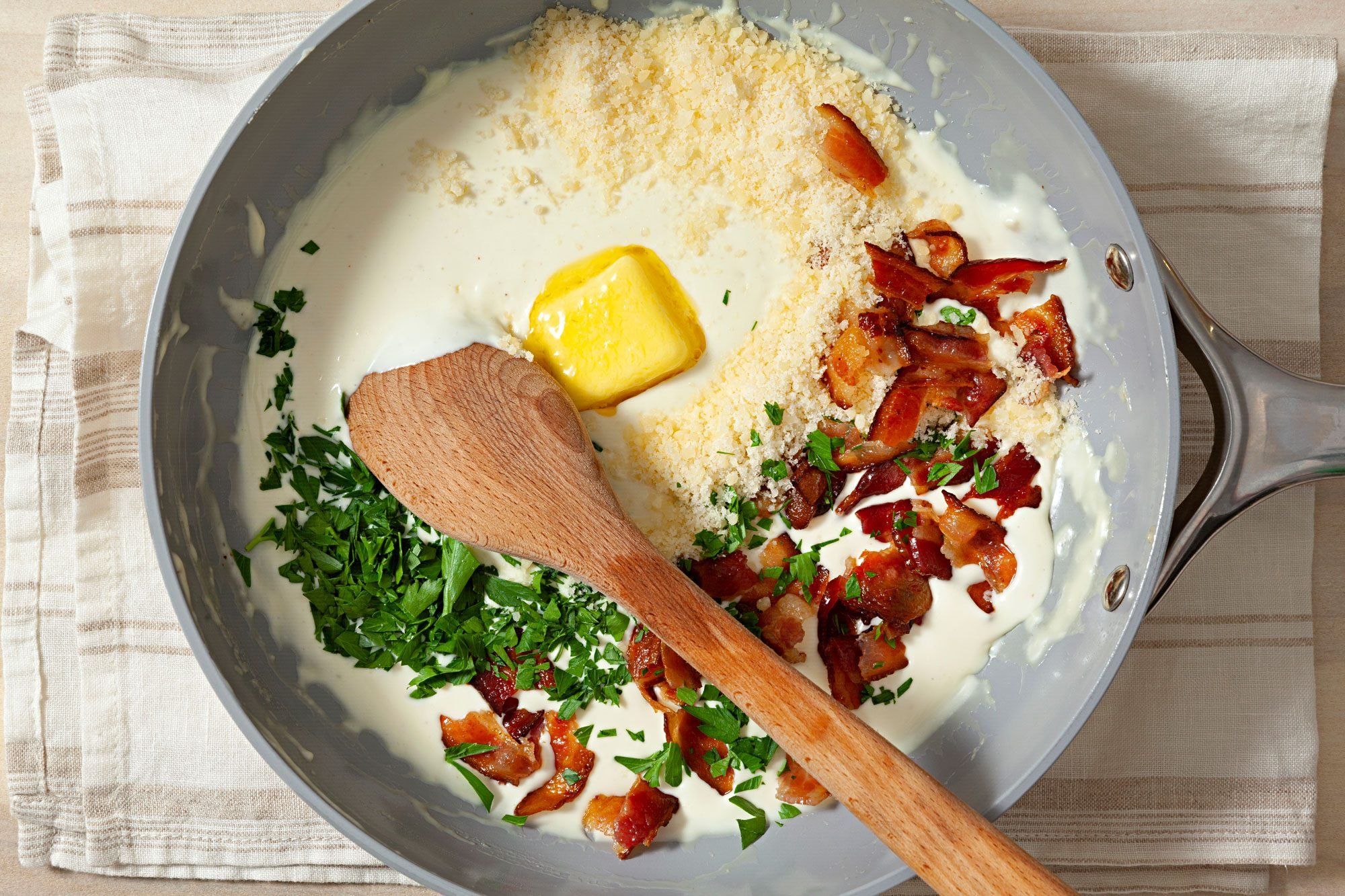 Add the butter, Parmesan cheese, crumbled bacon, fresh parsley and salt to the skillet with the reduced cream mixture