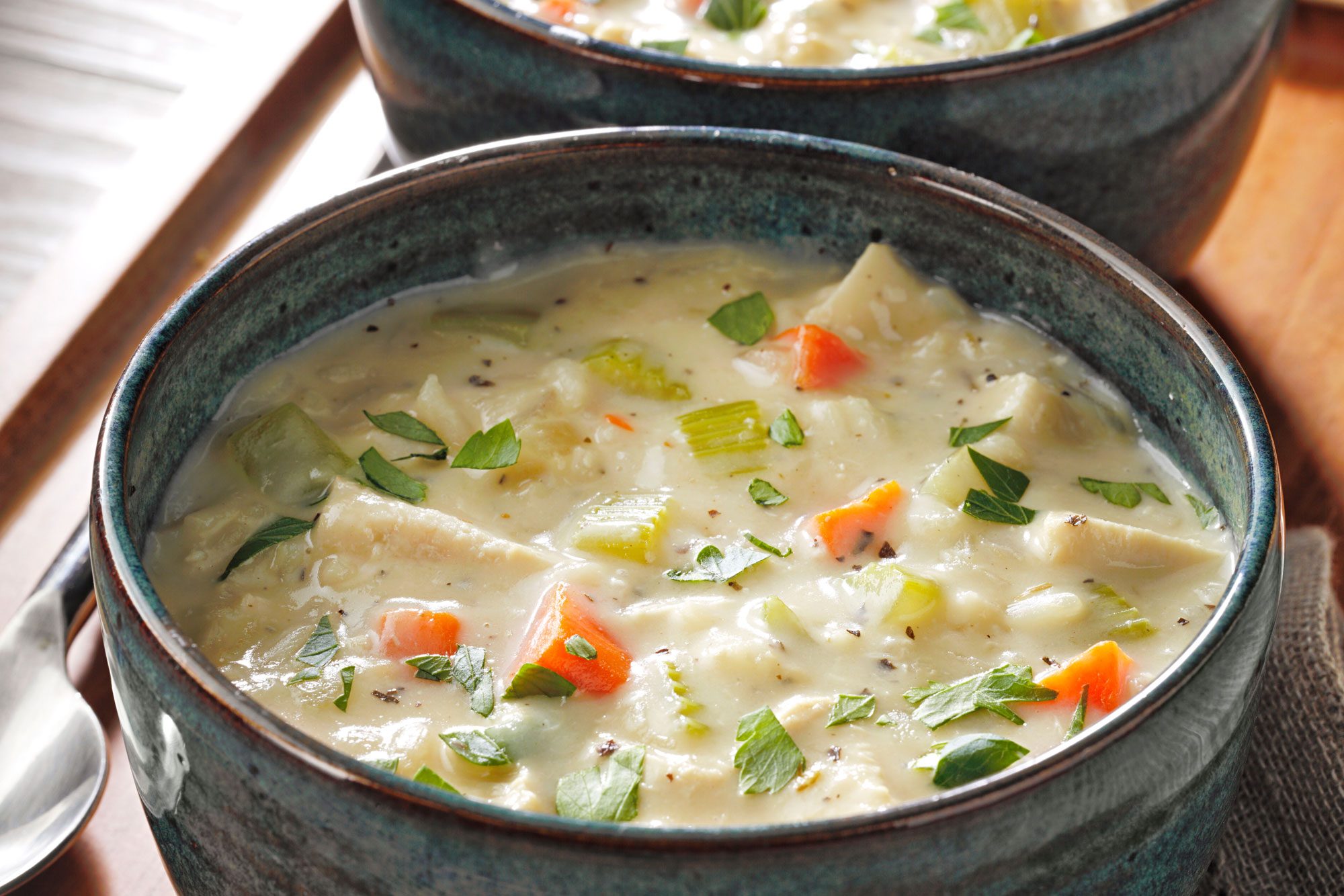 Two bowls of Creamy Chicken And Rice Soup with carrots and celery