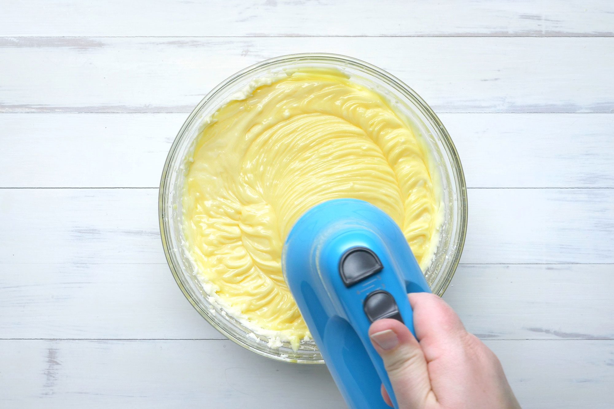 overhead shot; white background; In a large bowl, beat the cream cheese, butter and confectioners' sugar until smoot with electric whisker;