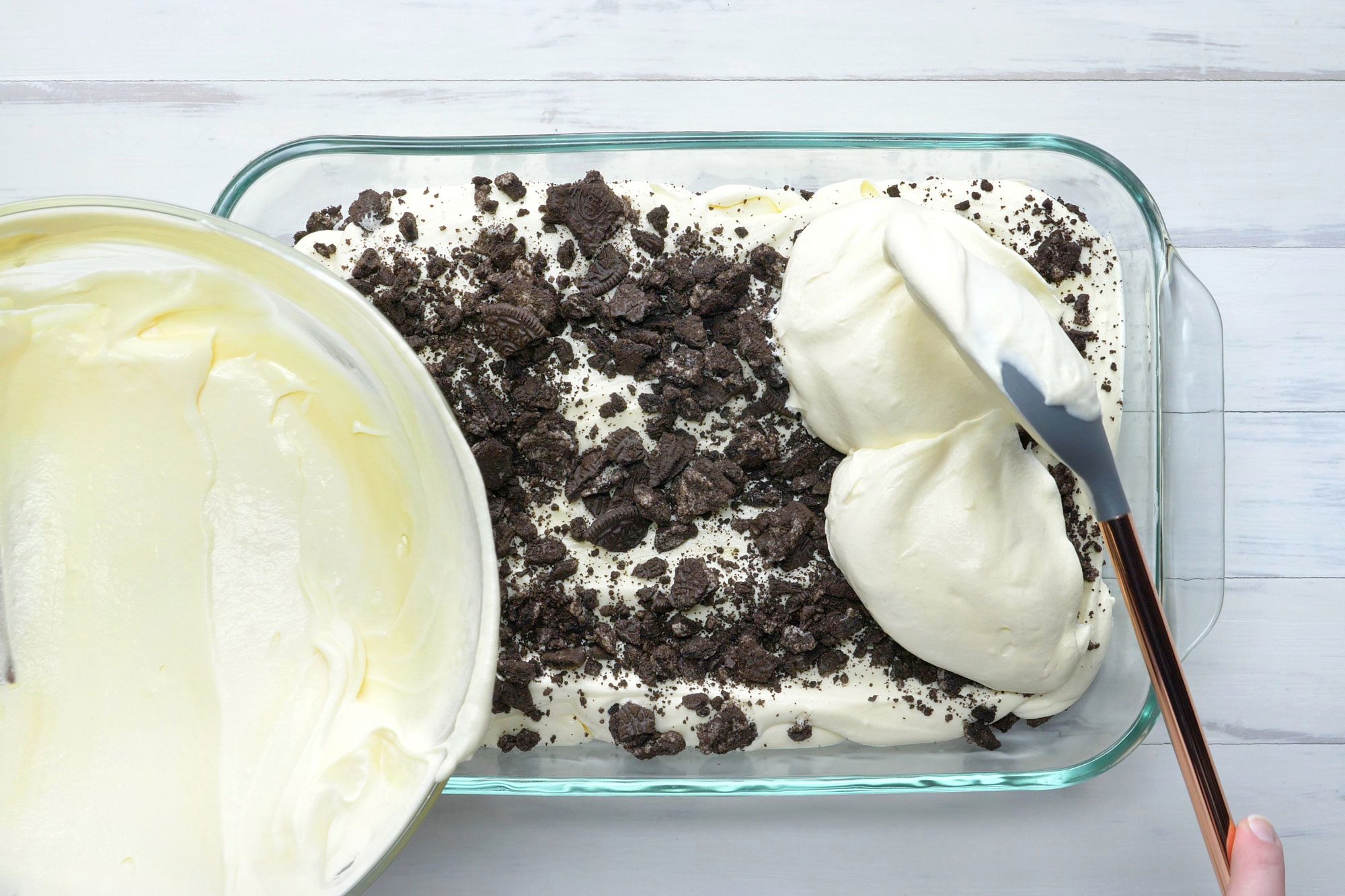 overhead shot; white background; Spreading crushed cookies into an ungreased dish, Layering with half the pudding mixture and half the remaining cookies;