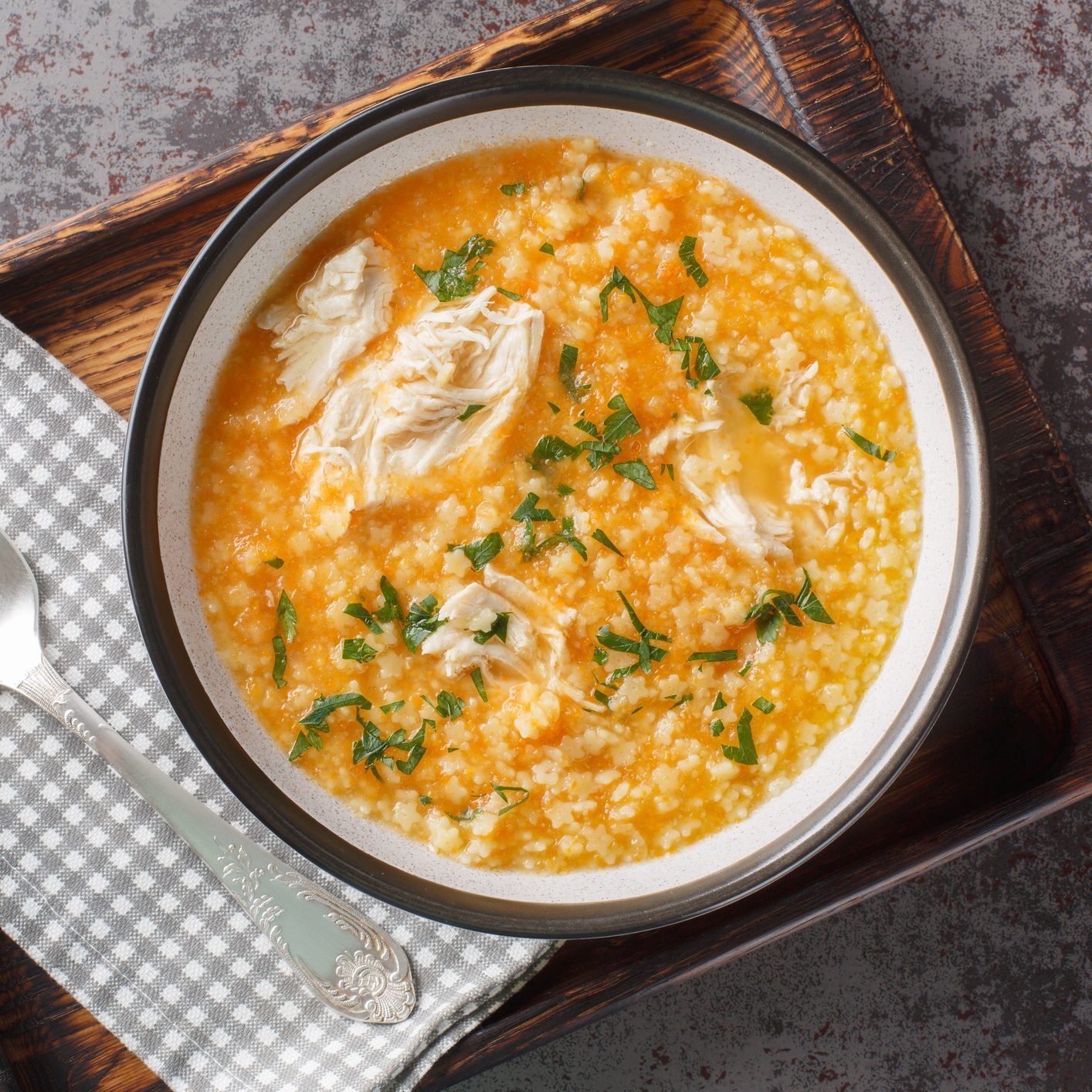 Homemade puree soup with pastina, chicken, vegetables and cheese close-up in a bowl. Horizontal top view