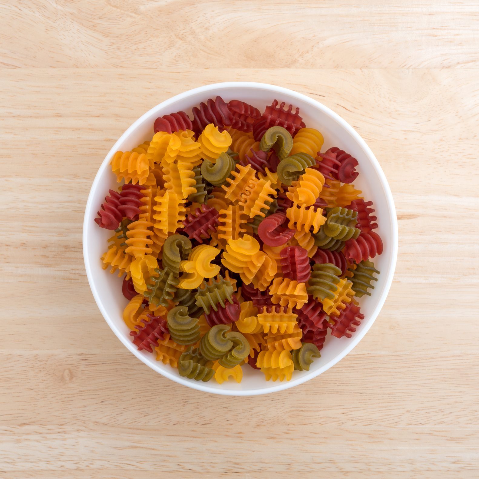 Corn vegetable radiatore pasta in a bowl on wood table