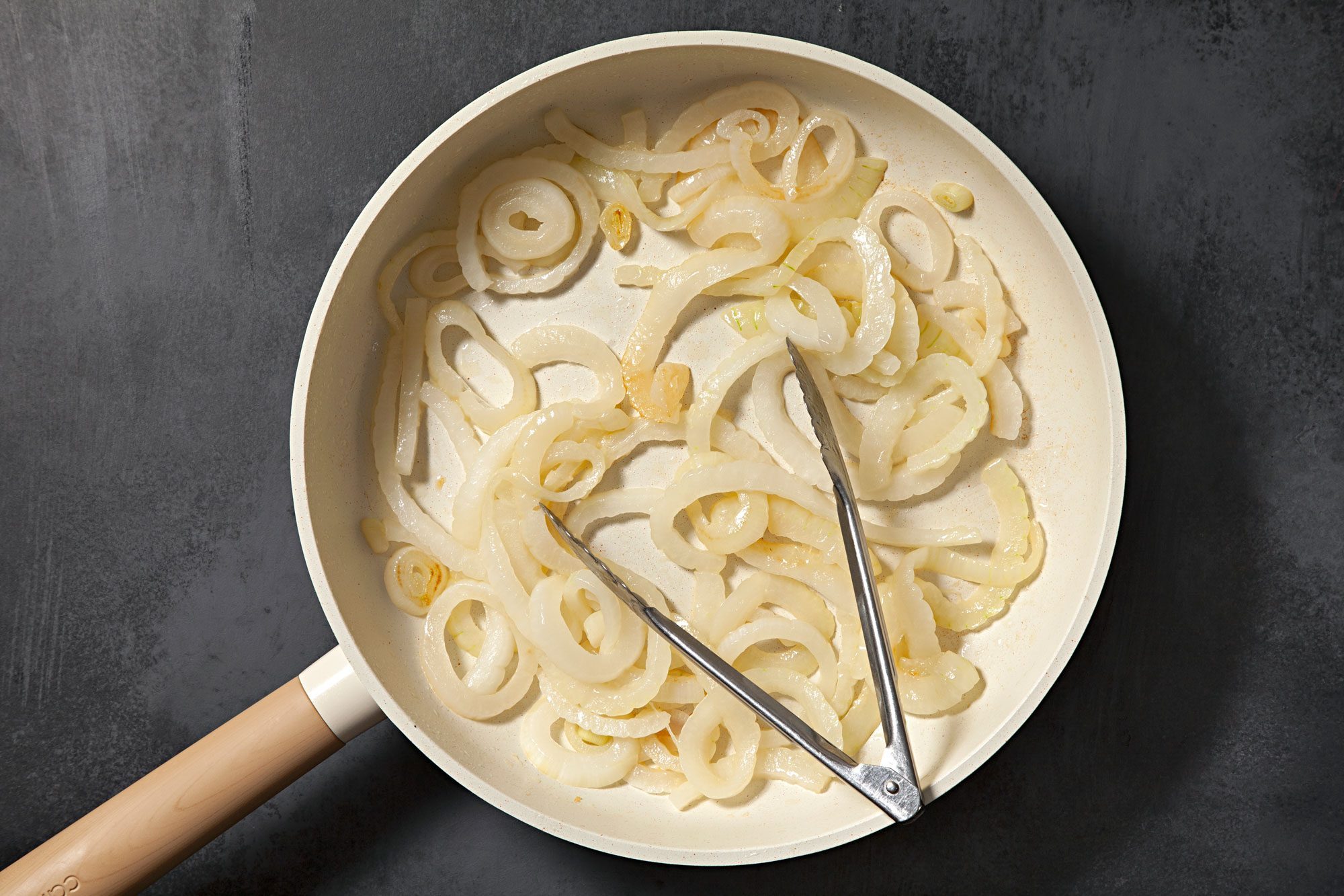 overhead shot; black background; in a small skillet, sauting onions;