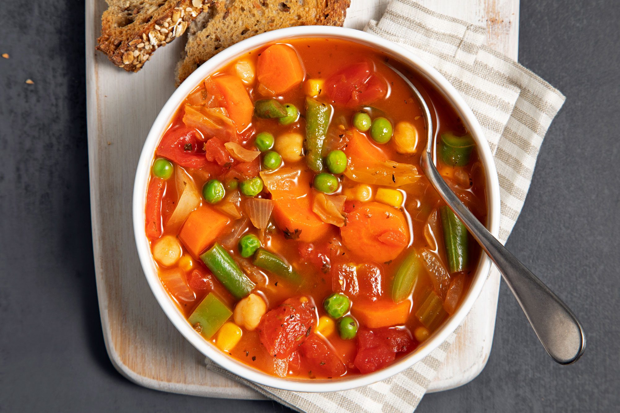 Hearty Vegetable Soup served in a bowl with bread and a spoon