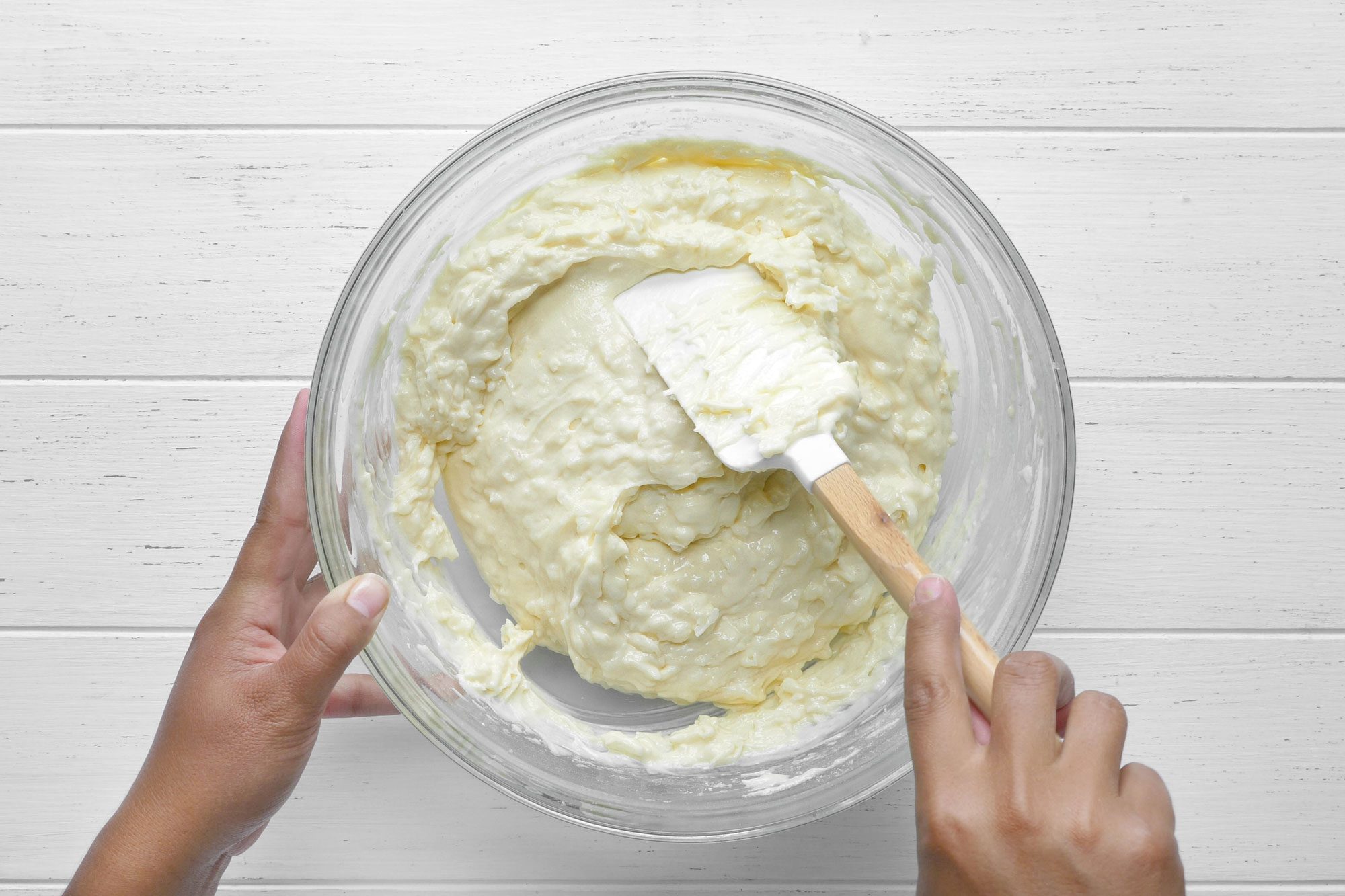 Overhead shot of batter; spatula; white wooden background;