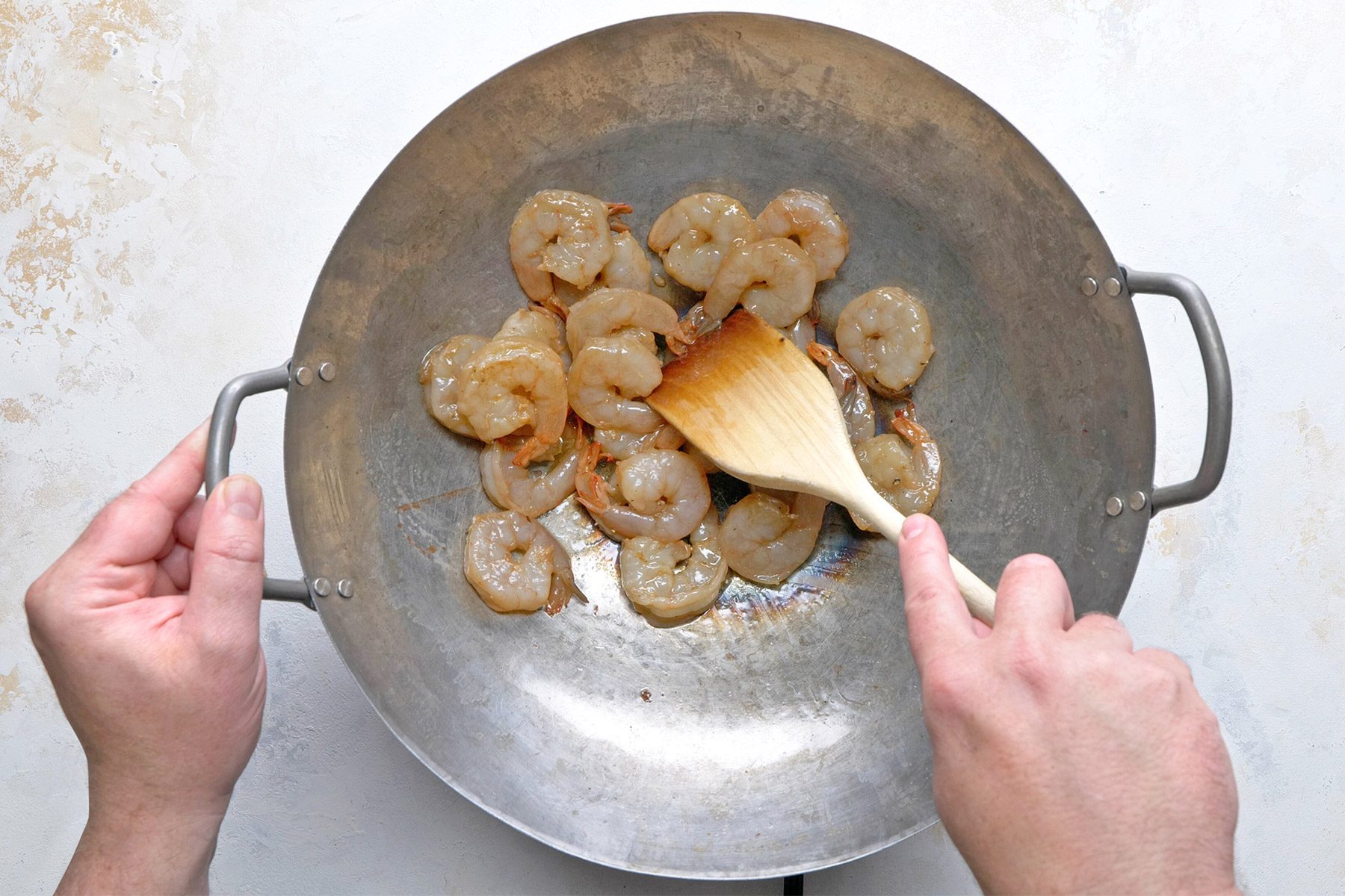 Overheda shot of a same skillet; over medium-high heat; cook shrimp until shirmp just starts to turn pink; remove shrimp to a bowl; marble background