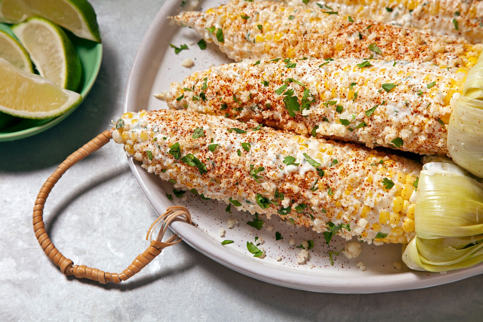 Mexican Street Corn served on large platter with lemon wedges in a small bowl