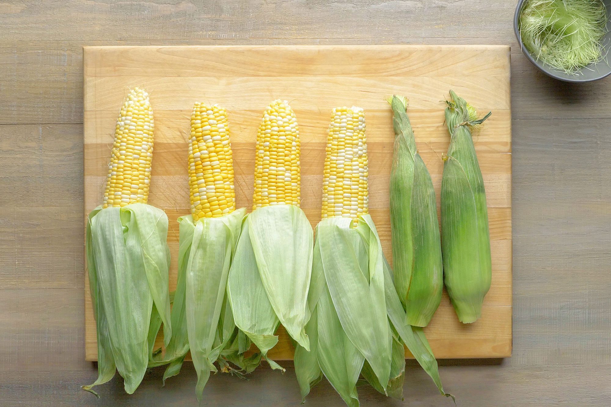 Carefully peel back the corn husks