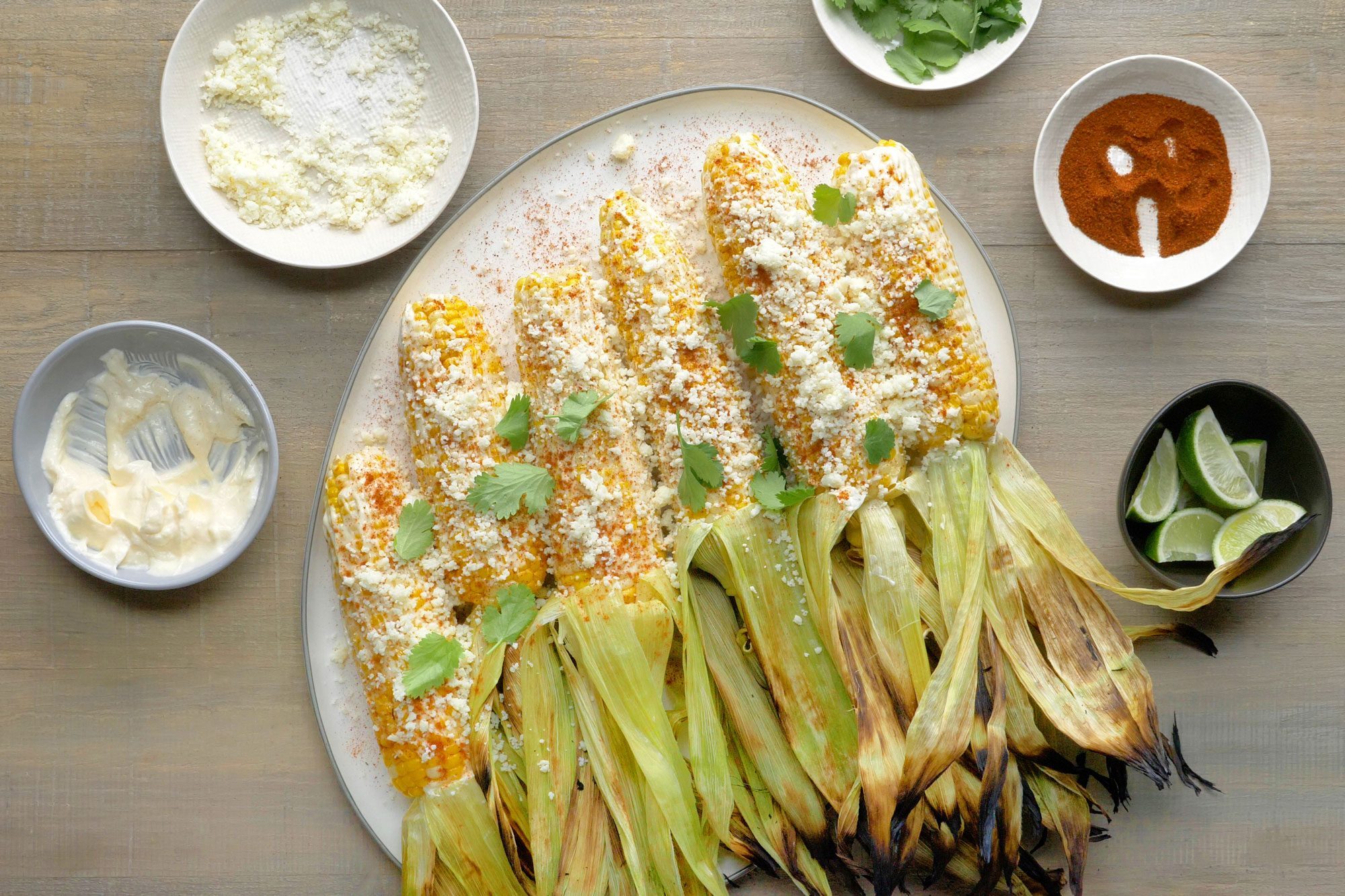 Peel back the husk on each ear of corn and spread the mixture generously over the kernels