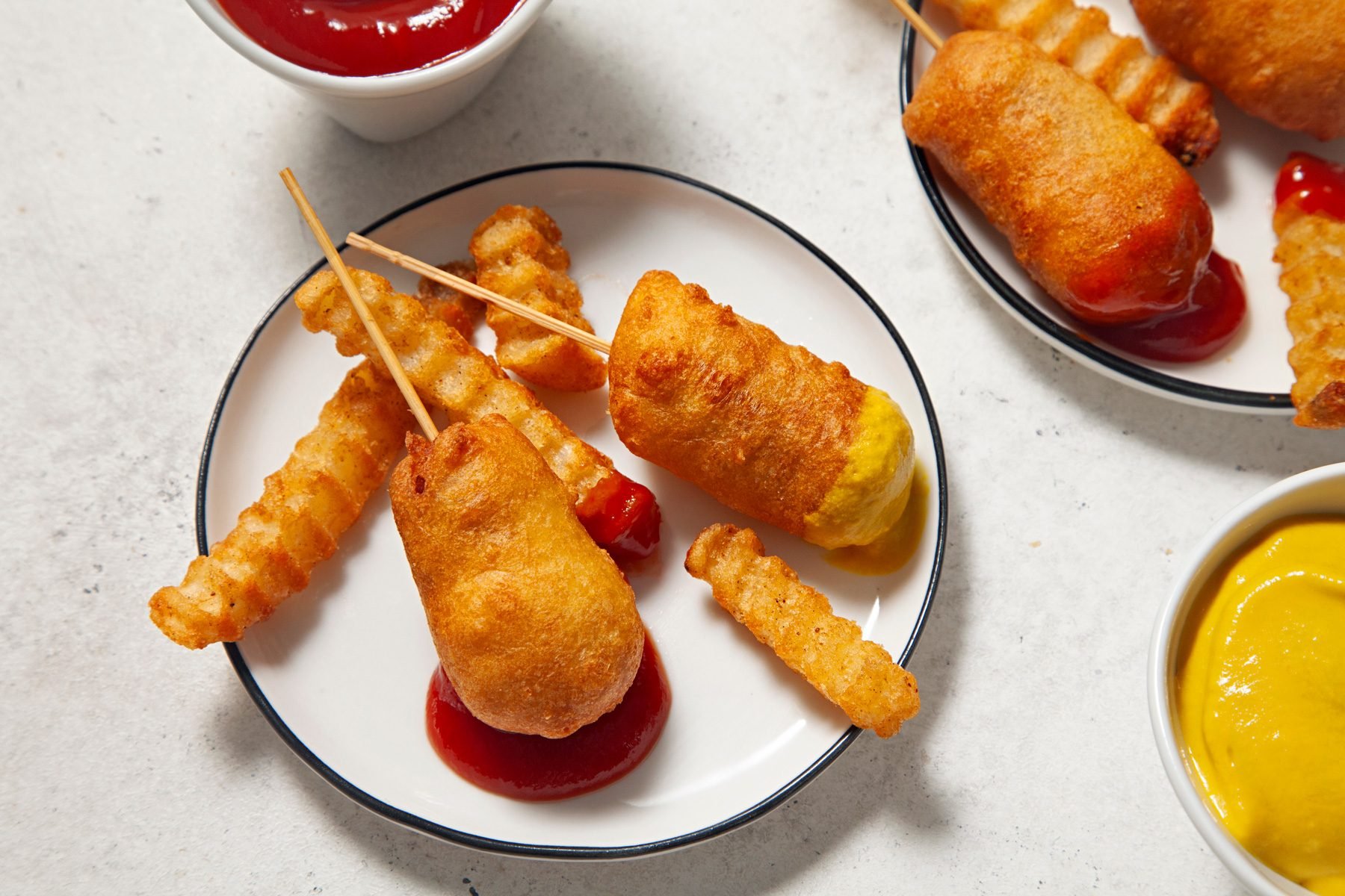 A plate of miniature corn dogs served with sauce