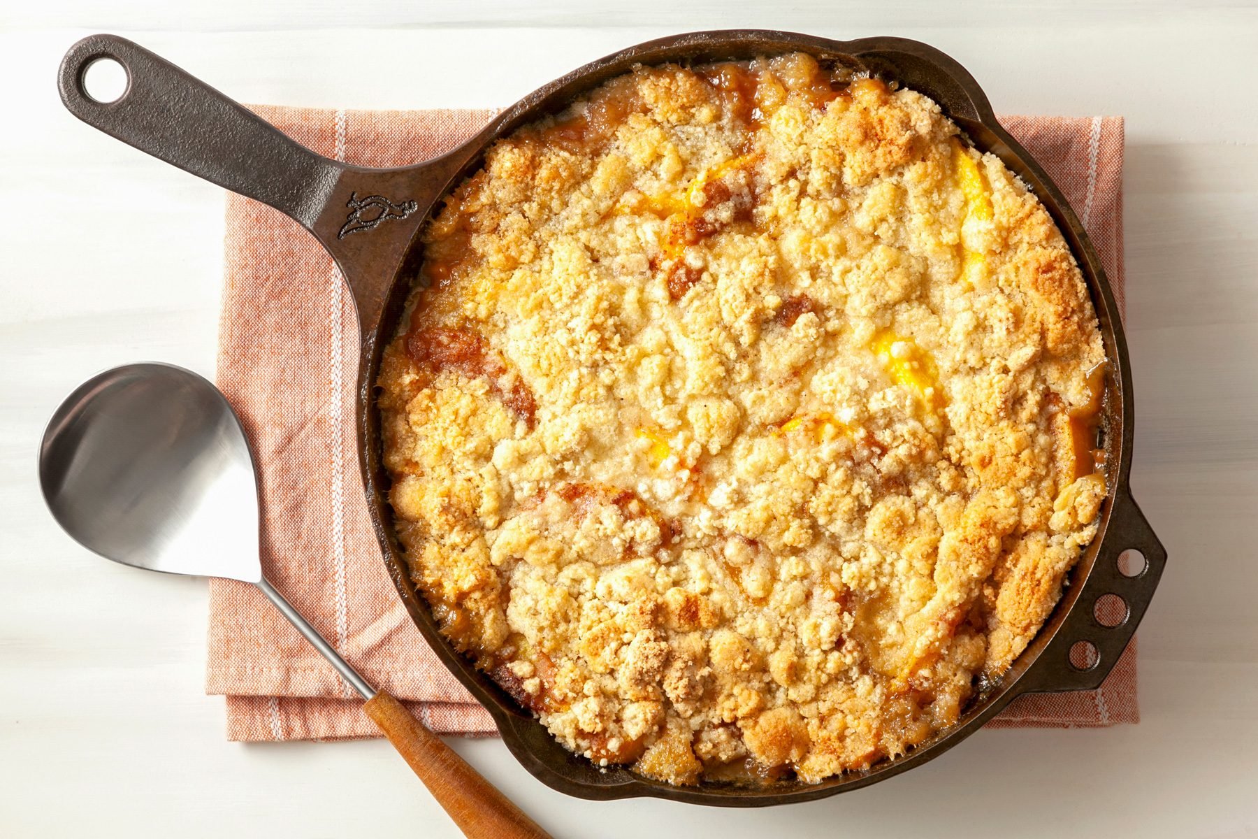 A cast-iron skillet filled with Peach Crumble Dessert 