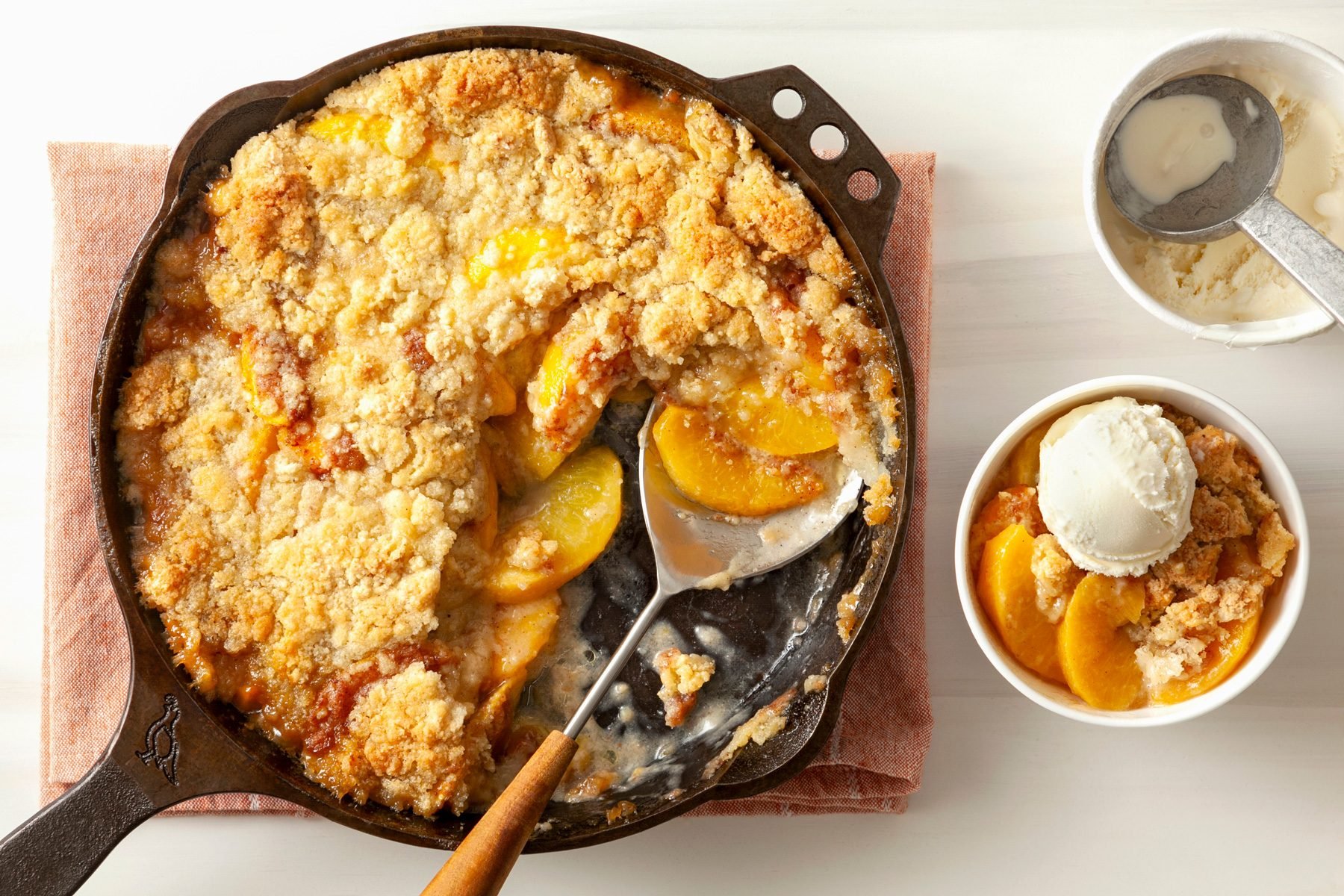 A cast-iron skillet filled with Peach Crumble Dessert 