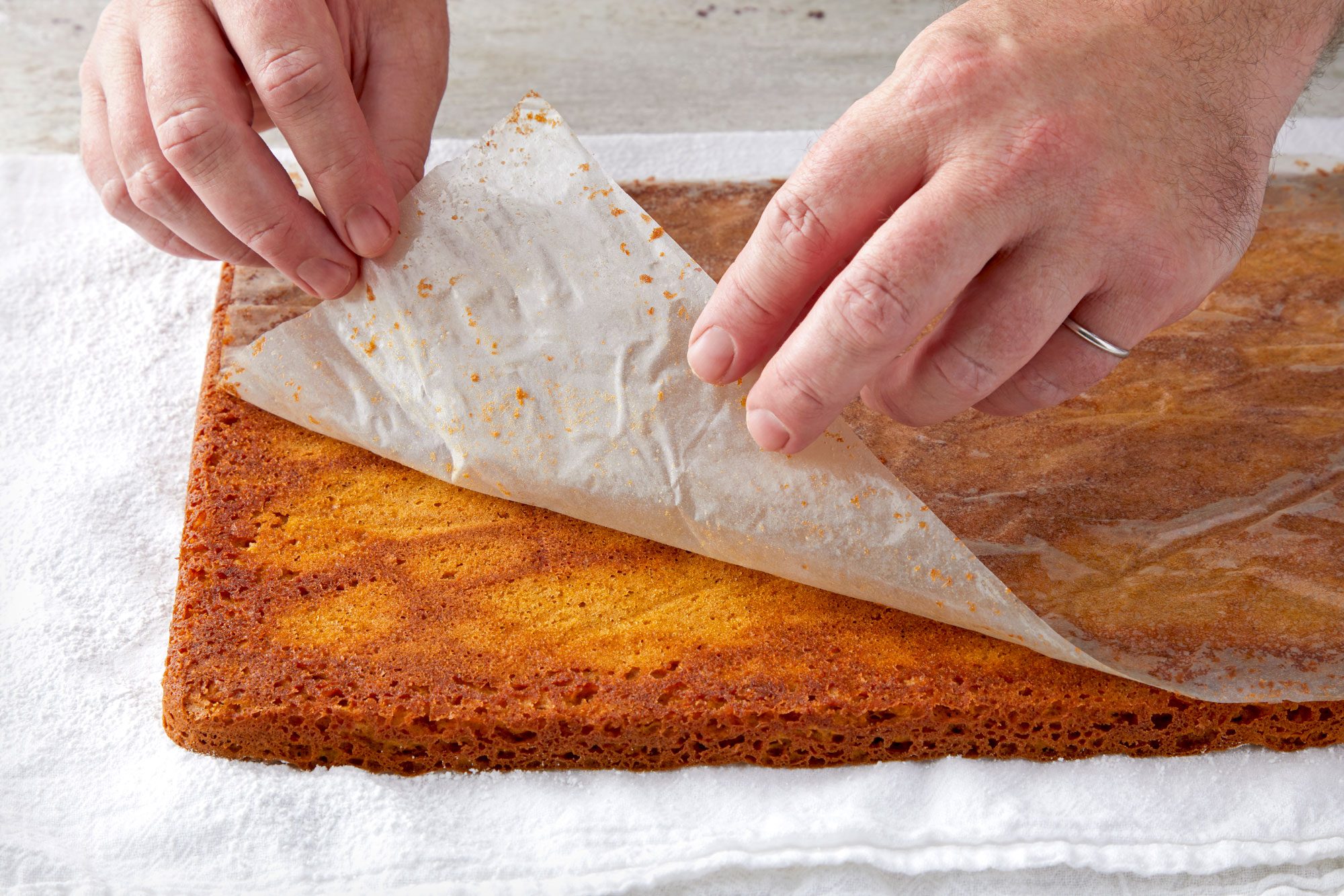 3/4th shot; Gently peeling off waxed paper over cake;