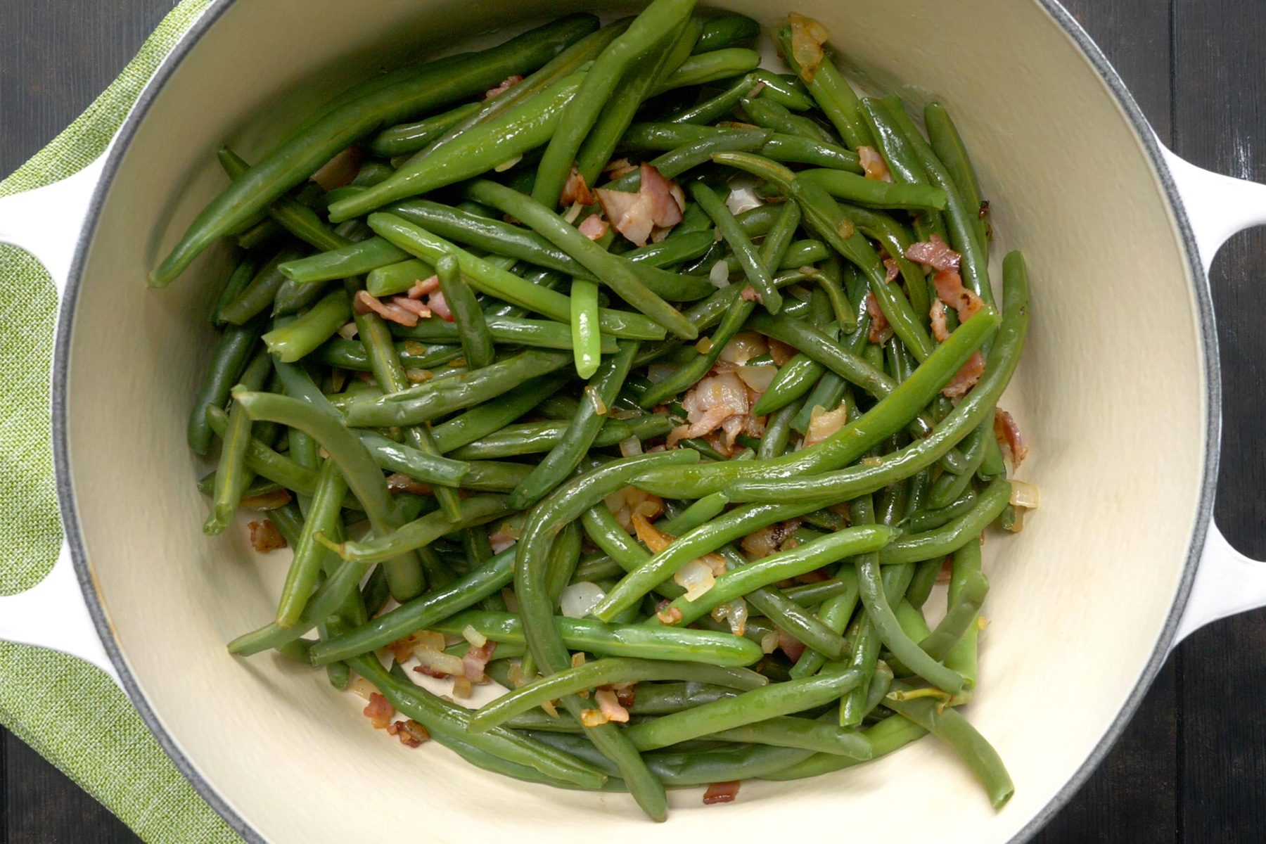 A large skillet filled with green beans and onions