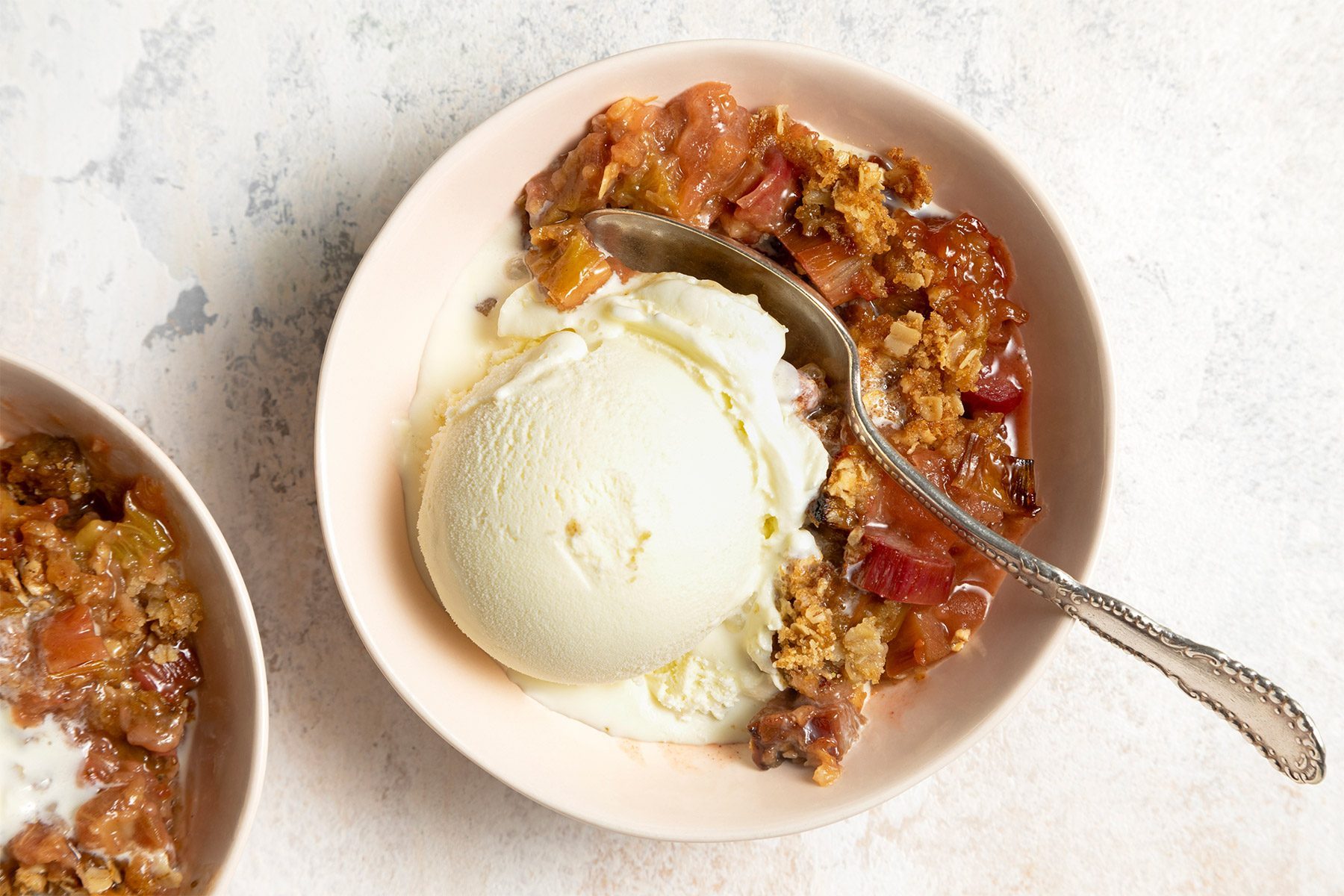 close shot of rhubarb crumble with a scoop of ice cream