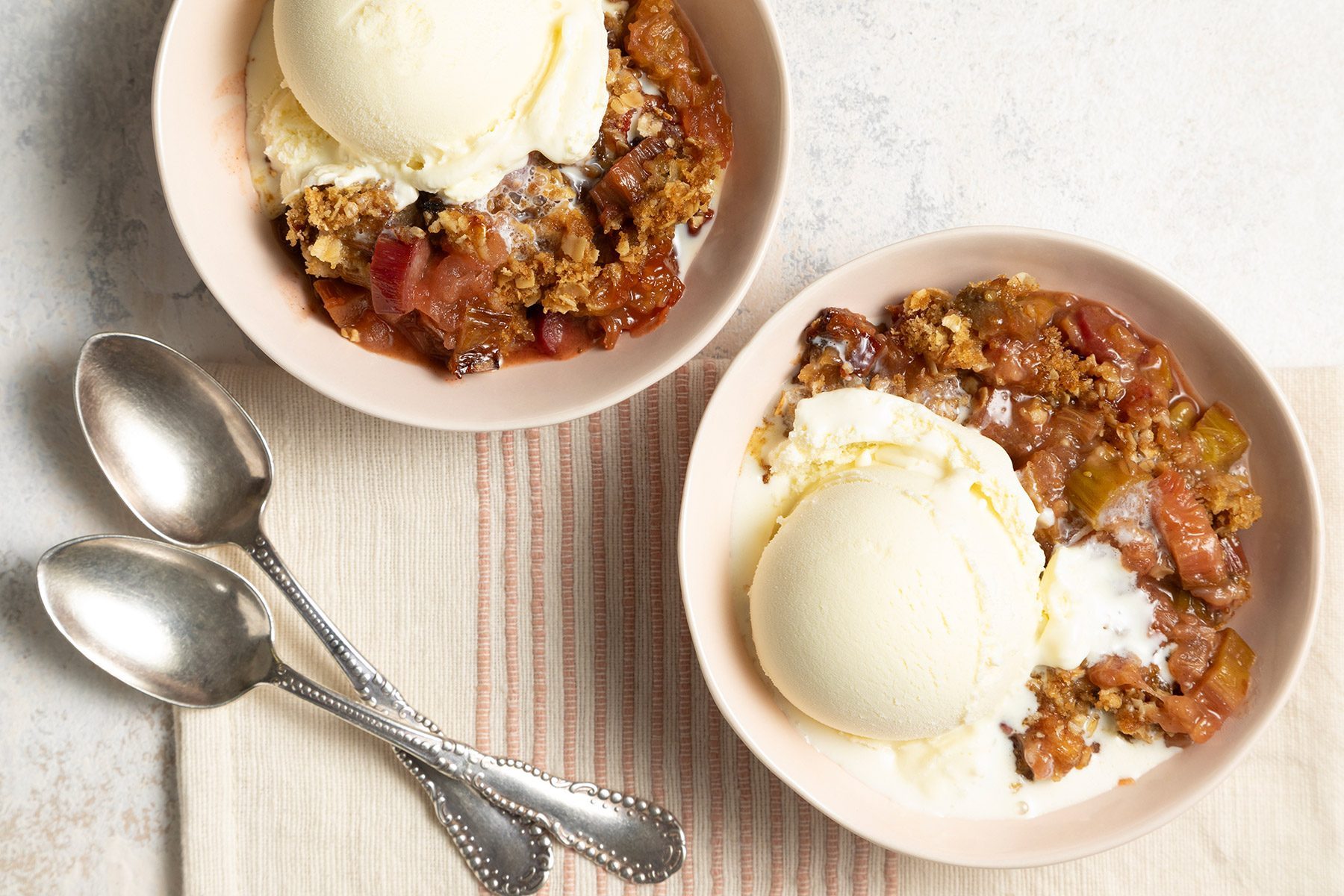 close shot of rhubarb crumble with a scoop of ice cream