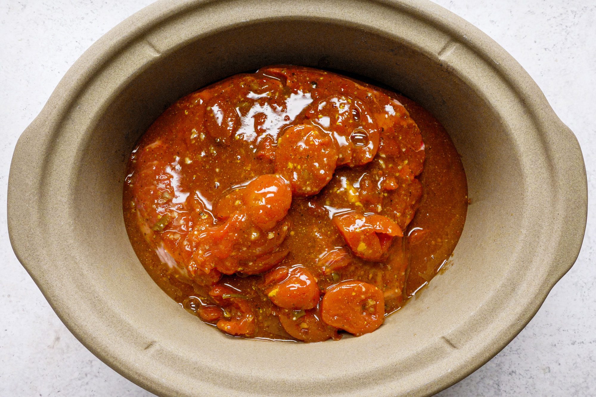 overhead shot of tomato mixture in a slow cooker bowl