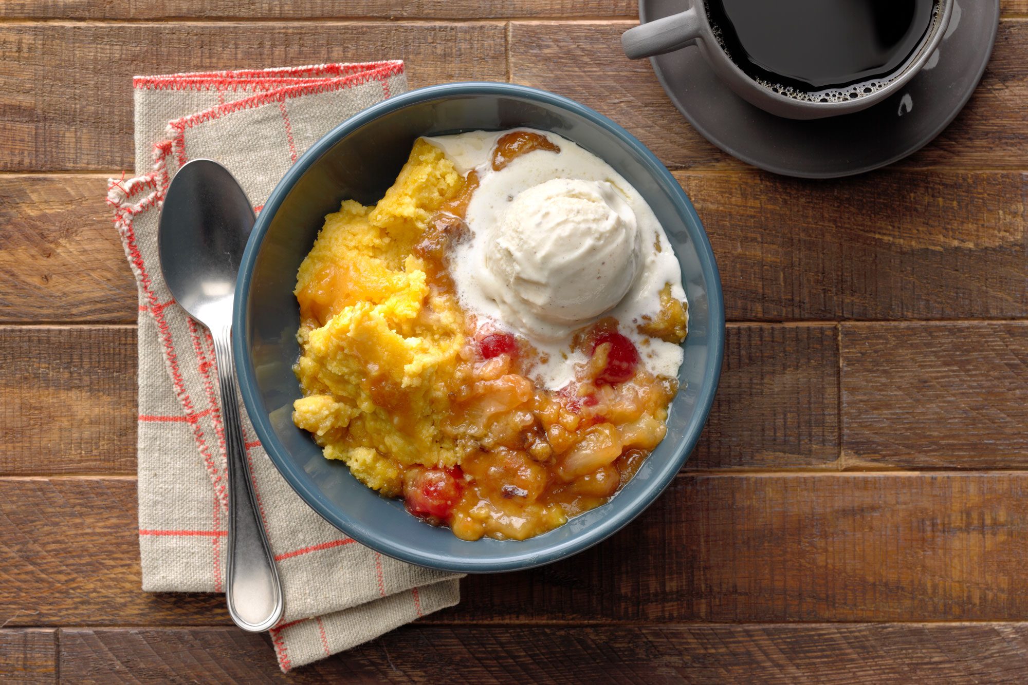 Delicious Slow Cooker Dump Cake served in a bowl with black coffee on the side