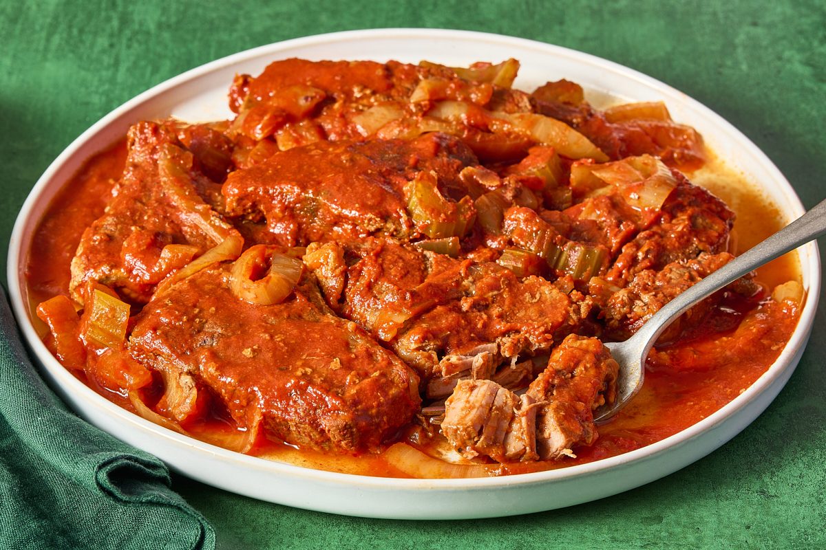 Closeup of slow cooker Swiss steak on a plate with a fork
