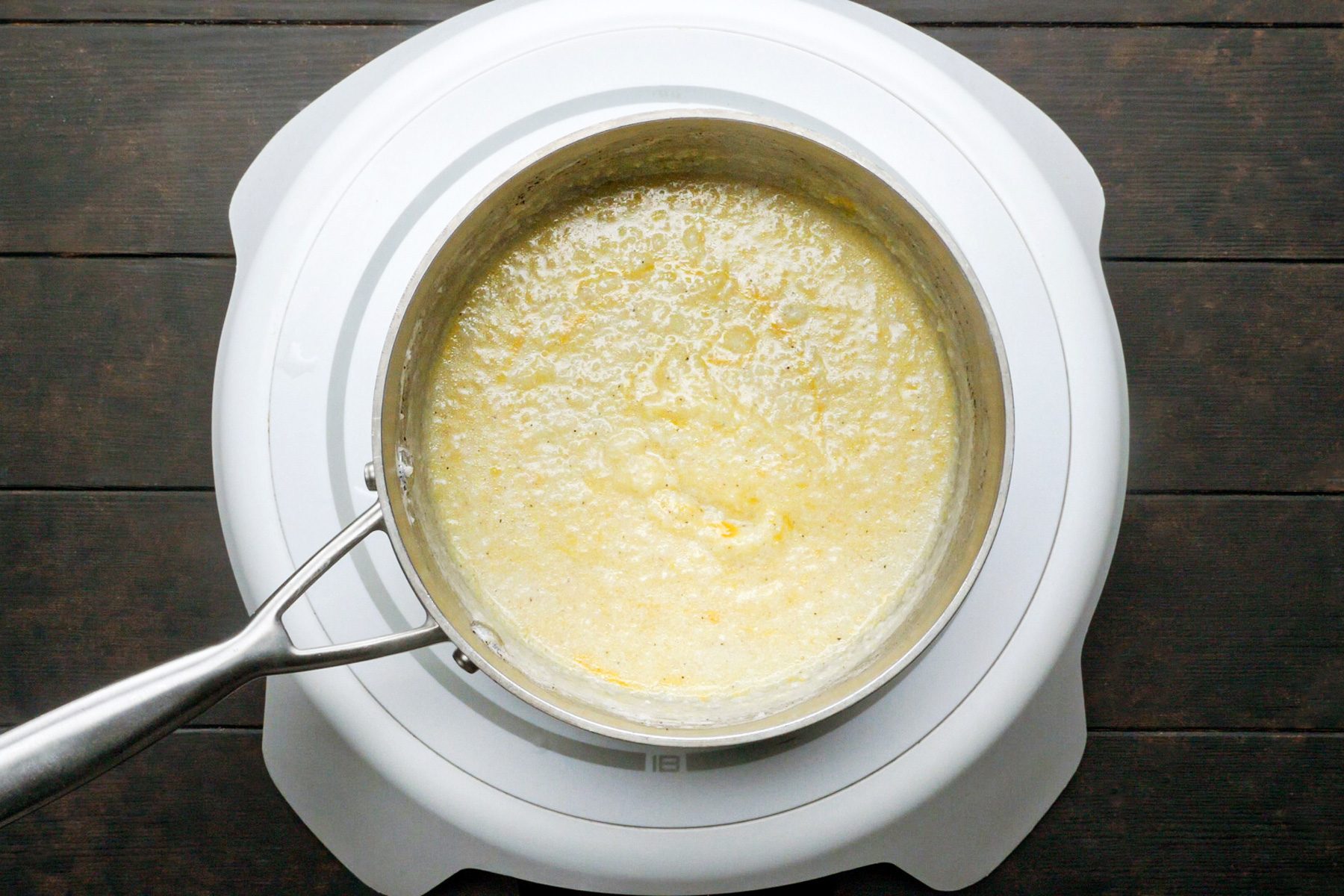 Milk mixture with cheese cooking in a saucepan