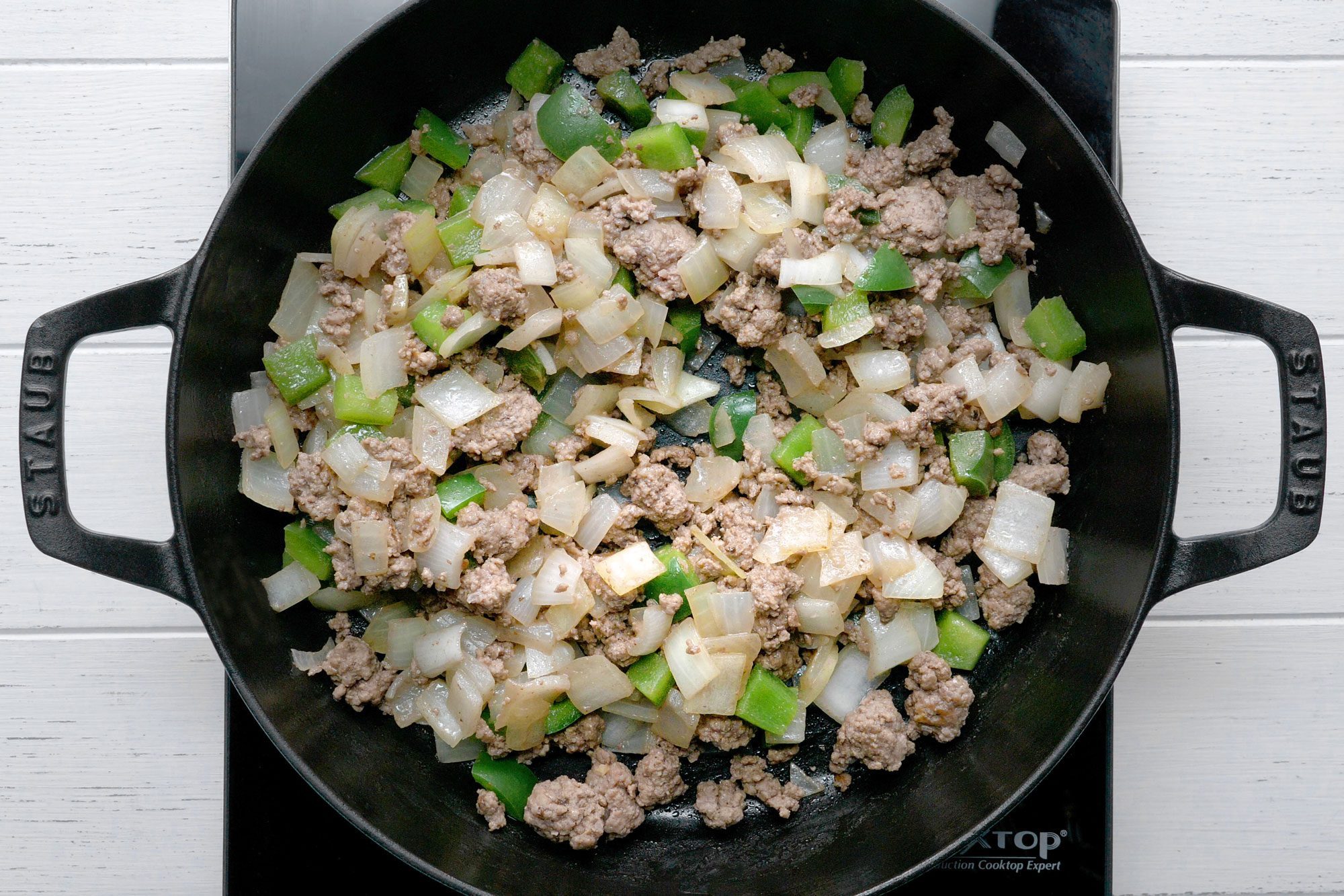 In a large skillet, cook the beef, onions and peppers