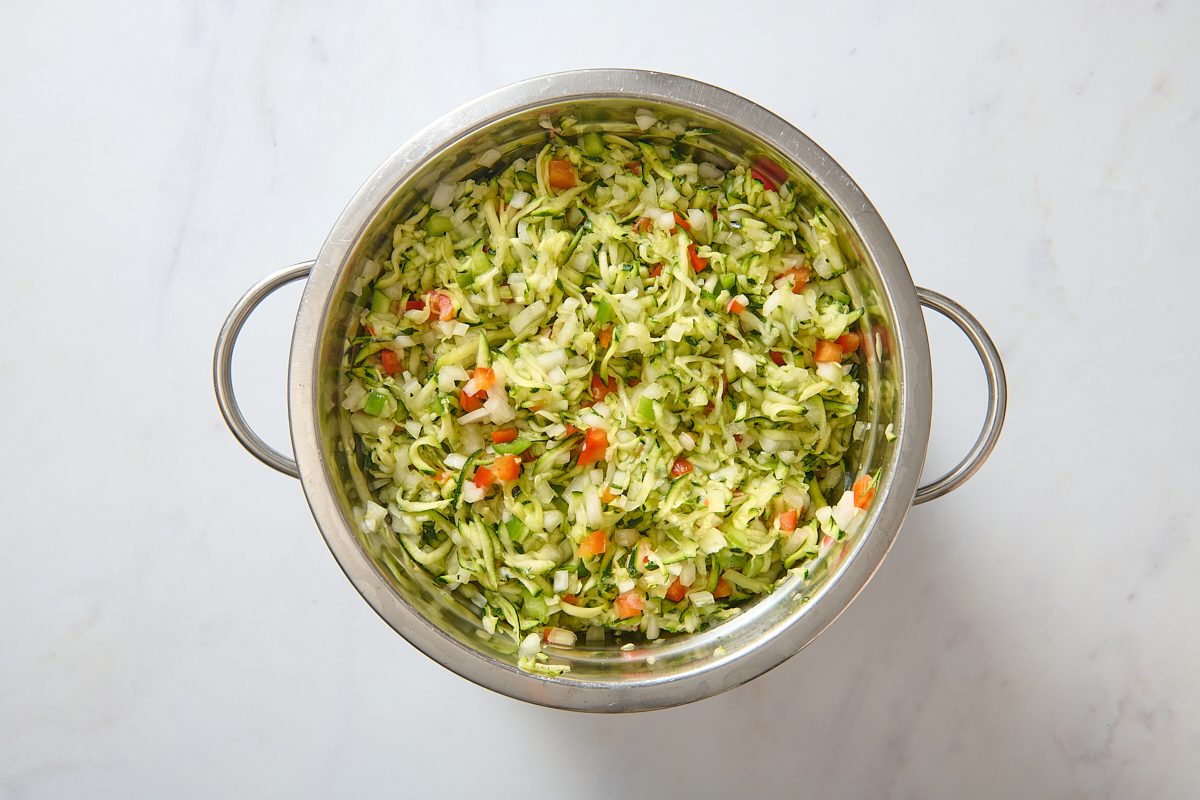 Zucchini relish ingredients draining in a colander