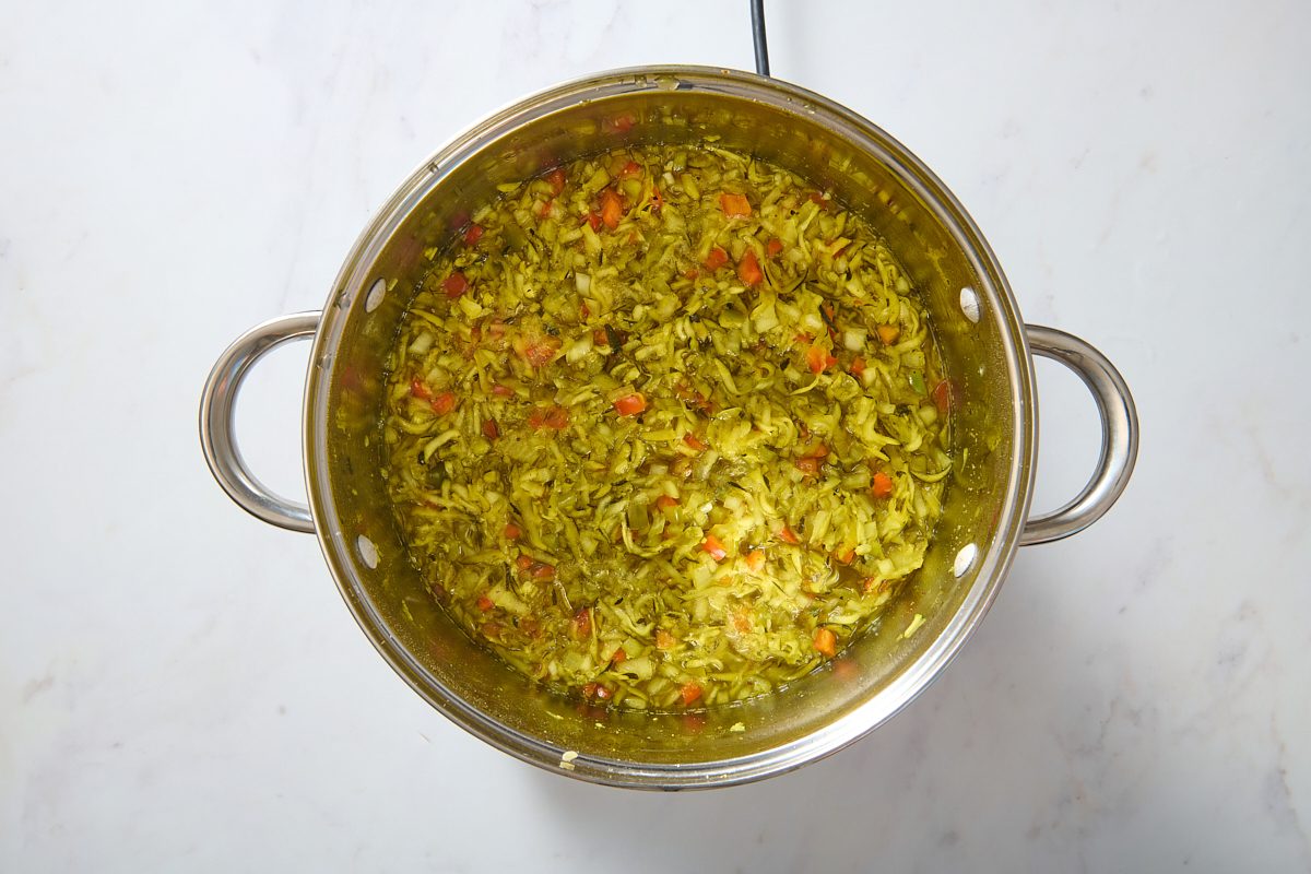 Zucchini relish vegetables simmering in a large pan