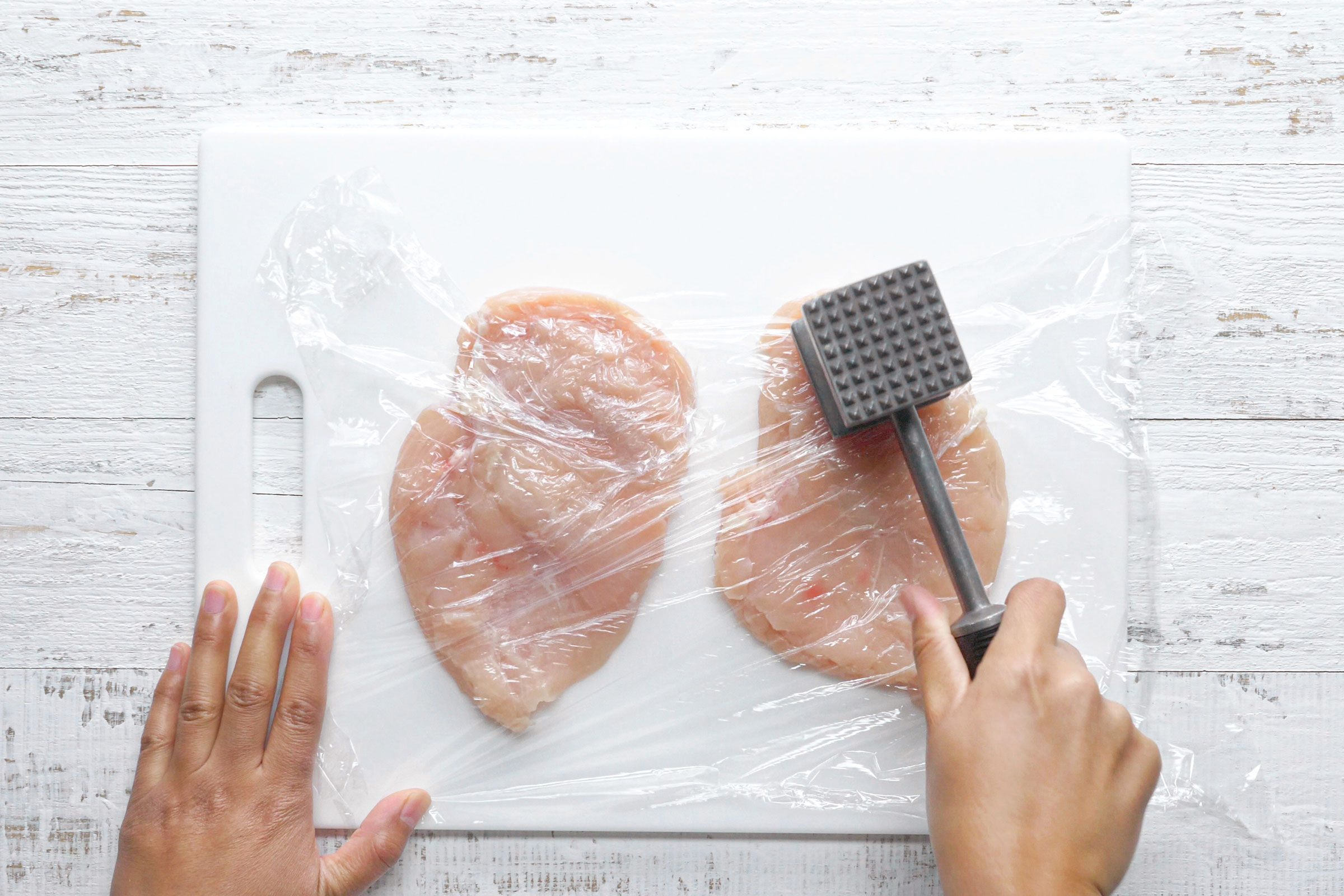 flattening chicken with a meat mallet 