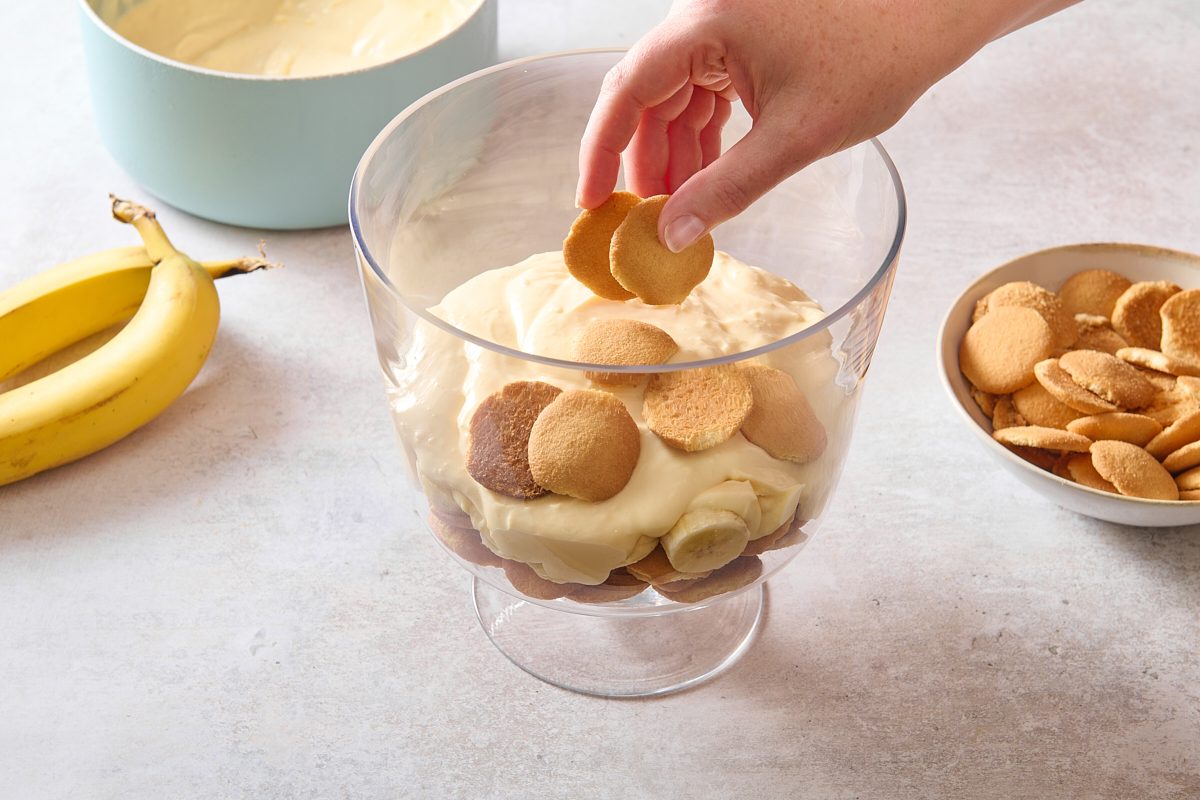 Layering banana pudding cup in a glass serving dish