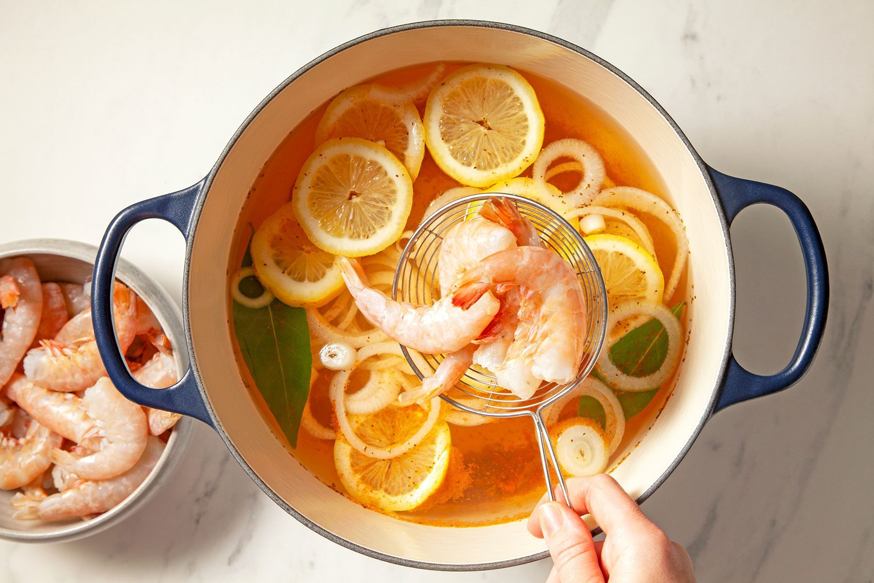 overhead shot of veggies and shrimp in a large saucepan