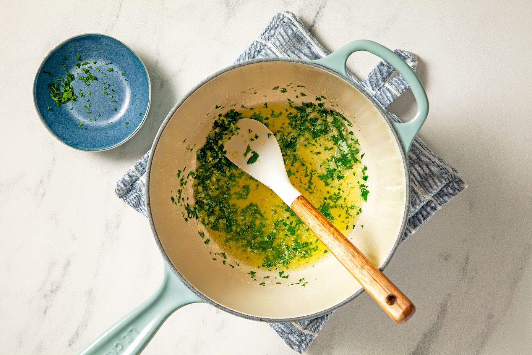 overhead shot of parsley added in the butter