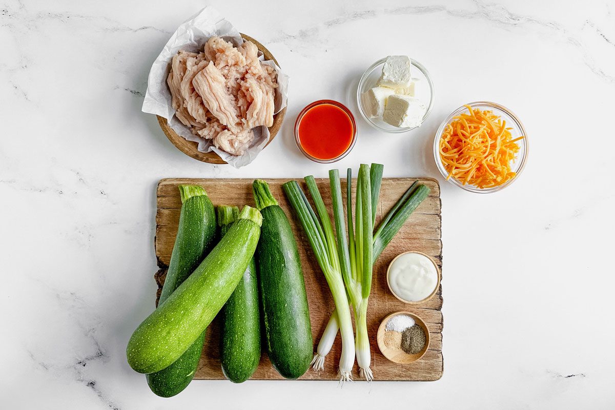 Ground chicken, buffalo sauce, cream cheese, shredded cheddar, zucchini, scallions, ranch dressing and spices for making Taste of Home Buffalo chicken zucchini boats.