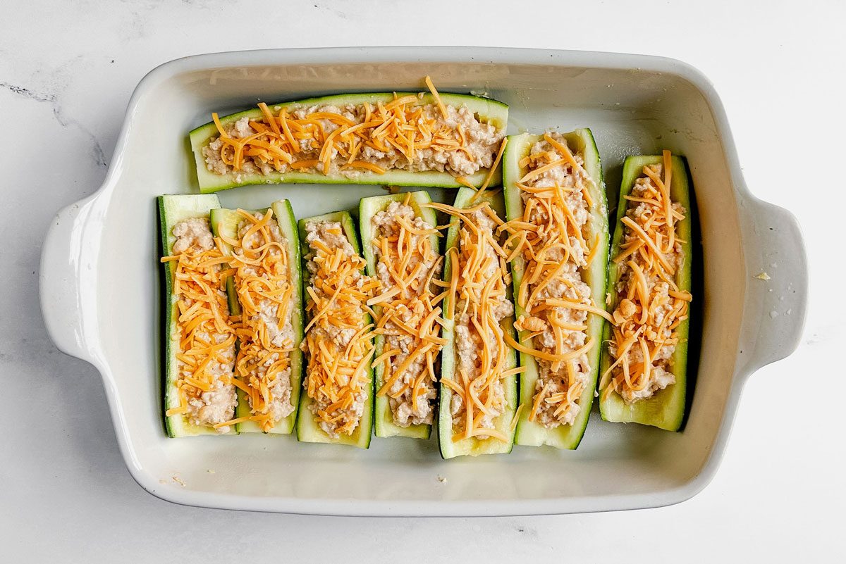 Unbaked Buffalo Chicken Zucchini Boats in a ceramic baking dish for Taste of Home.