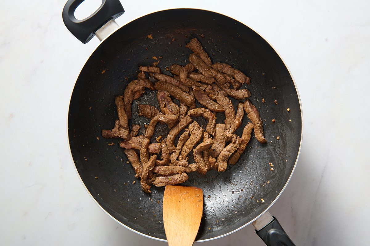 Steak strips being cooked in a wok