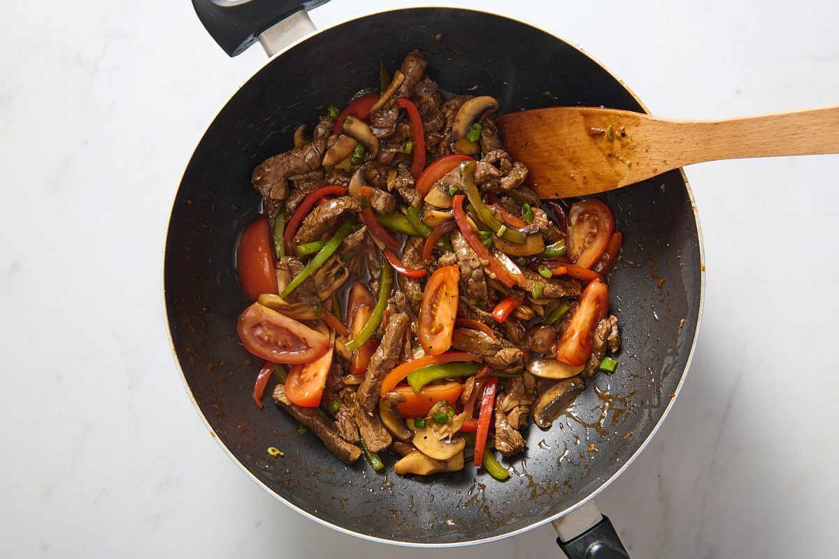 Steak, vegetables and sauce all cooked together in a wok