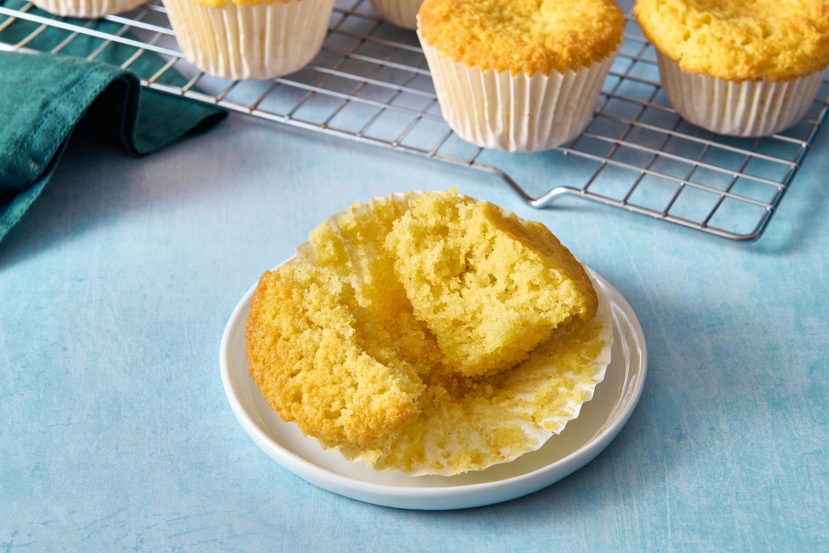 Closeup of a cornbread muffin broken apart on a plate