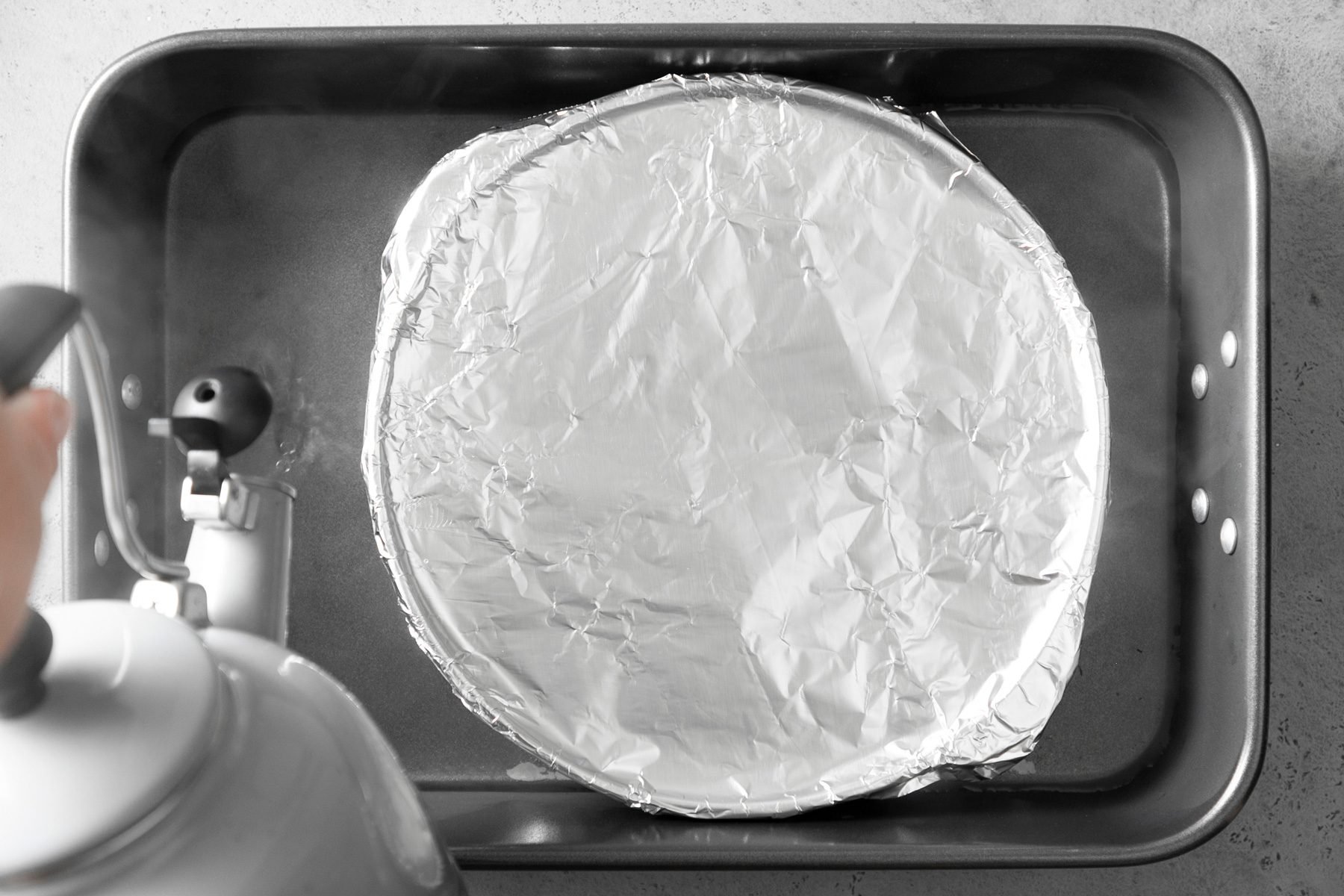 Place the pie plate in a larger baking pan and pour hot water to reach halfway up the sides of the pie plate.