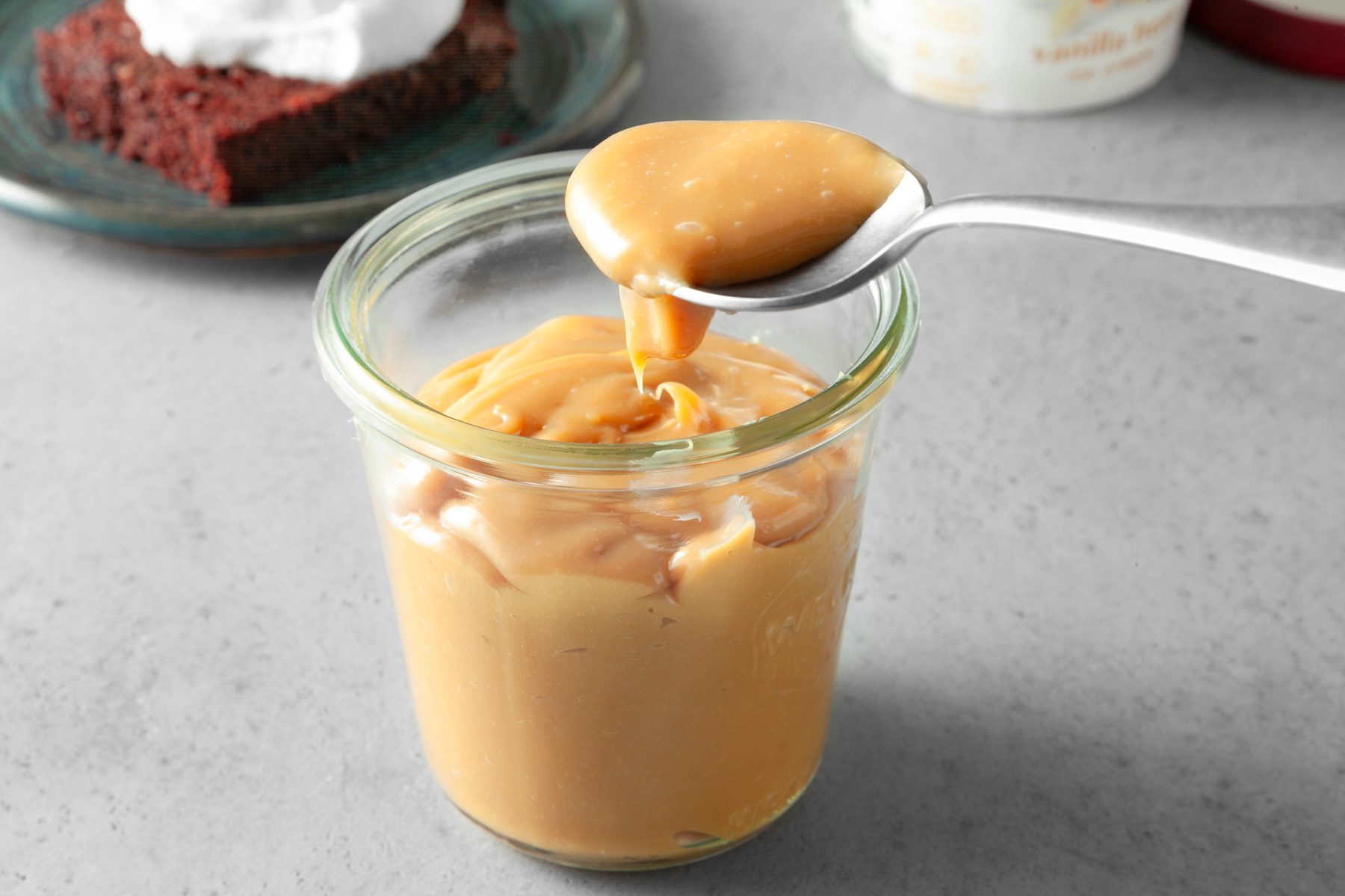 Dulce De Leche sauce in a cup with spoon