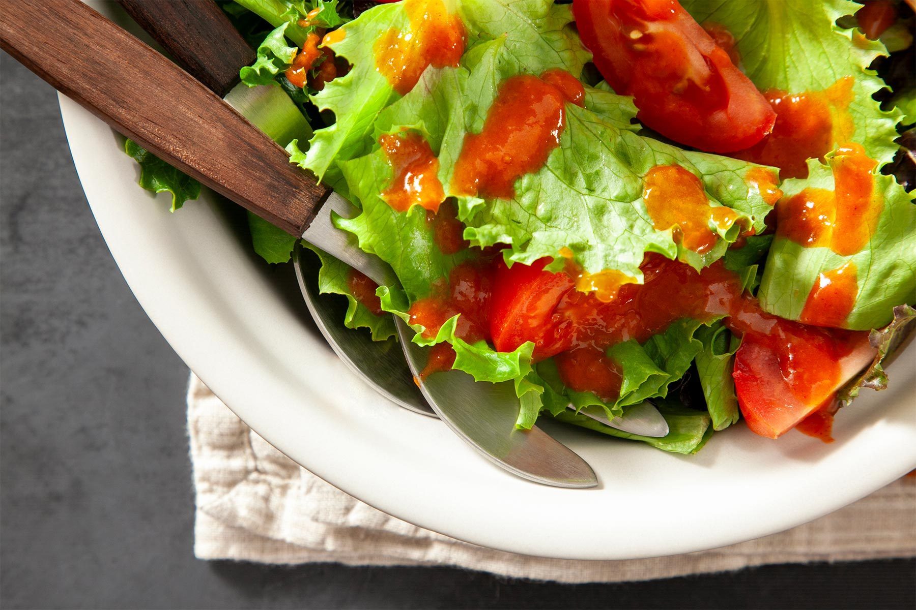 close shot of green salad garnished with classic french dressing