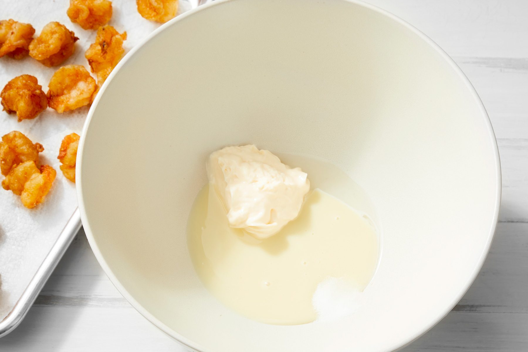 white background; in a large bowl combined mayonnaise, sweetened condensed milk, vinegar and salt;