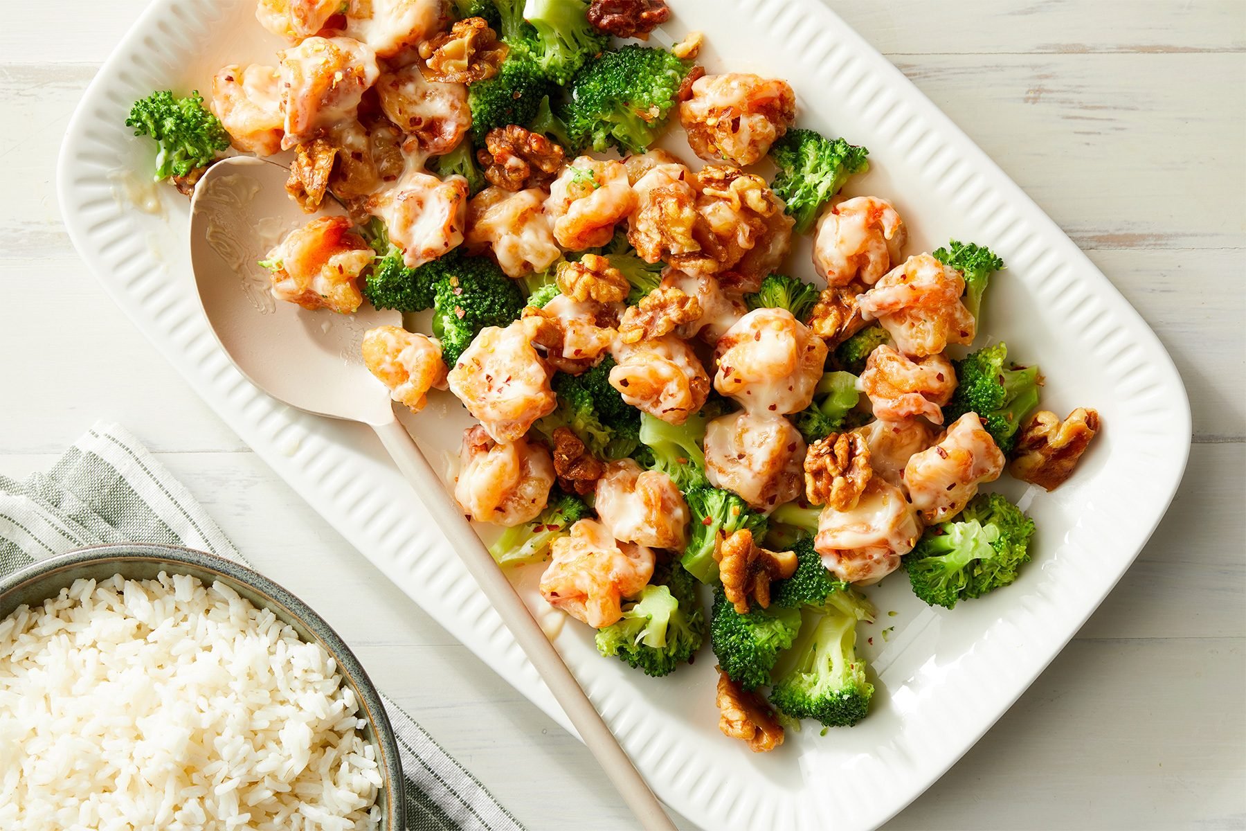 white background; Honey Walnut Shrimps served in a large rectangular plate over kitchen towel; with rice bowl;