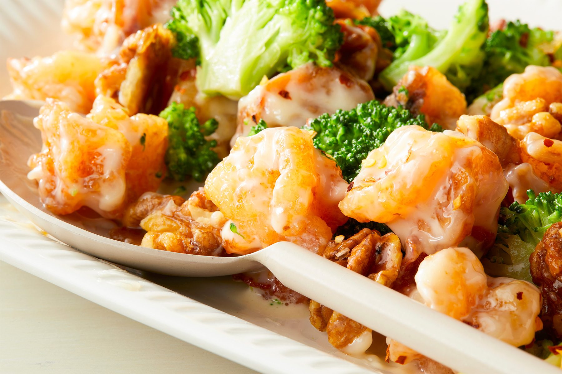 Horizontal Push shot; close shot; Honey Walnut Shrimps served in a large rectangular plate;