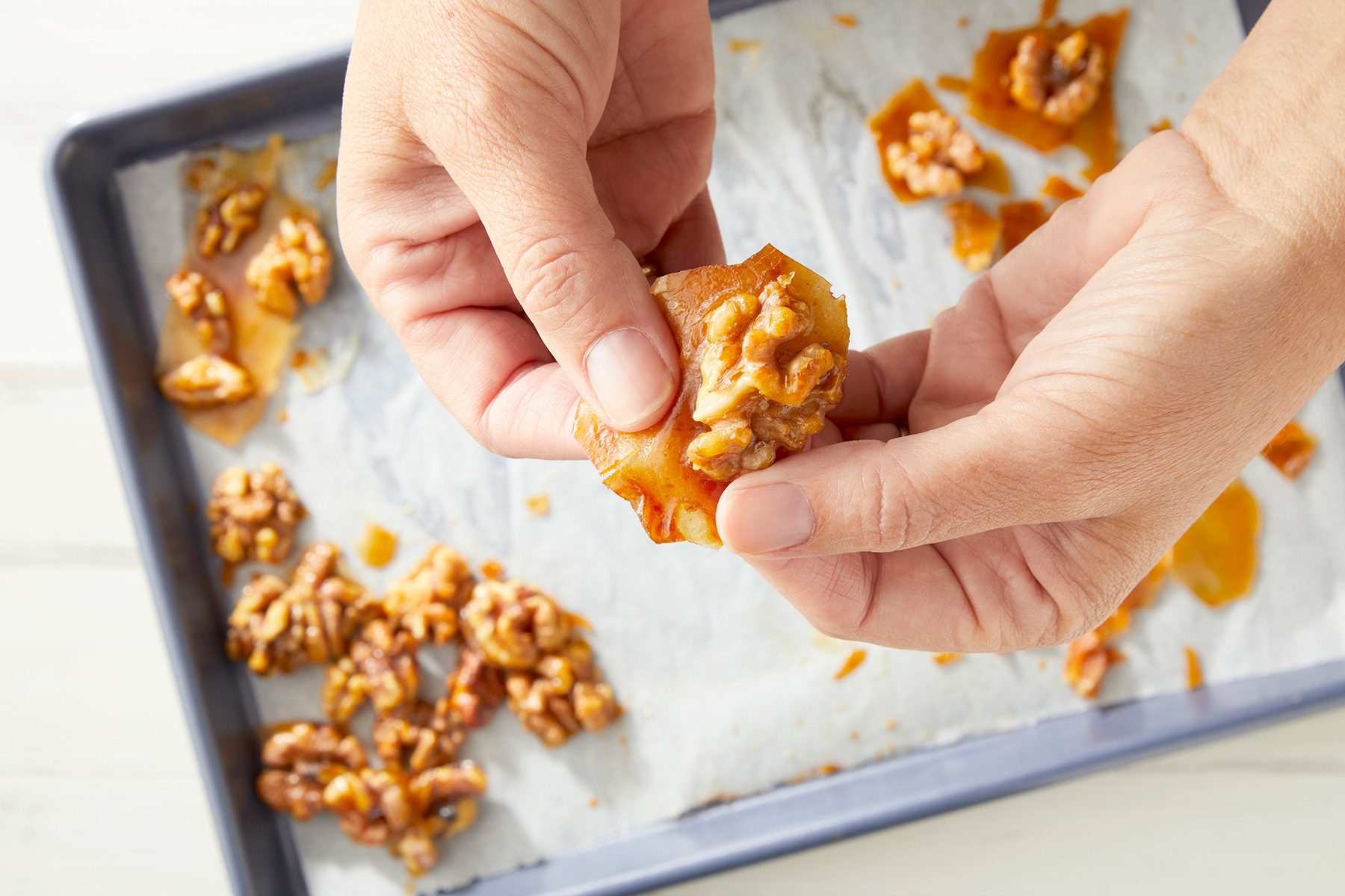 overhead shot; white background; Breaking candy with hands;