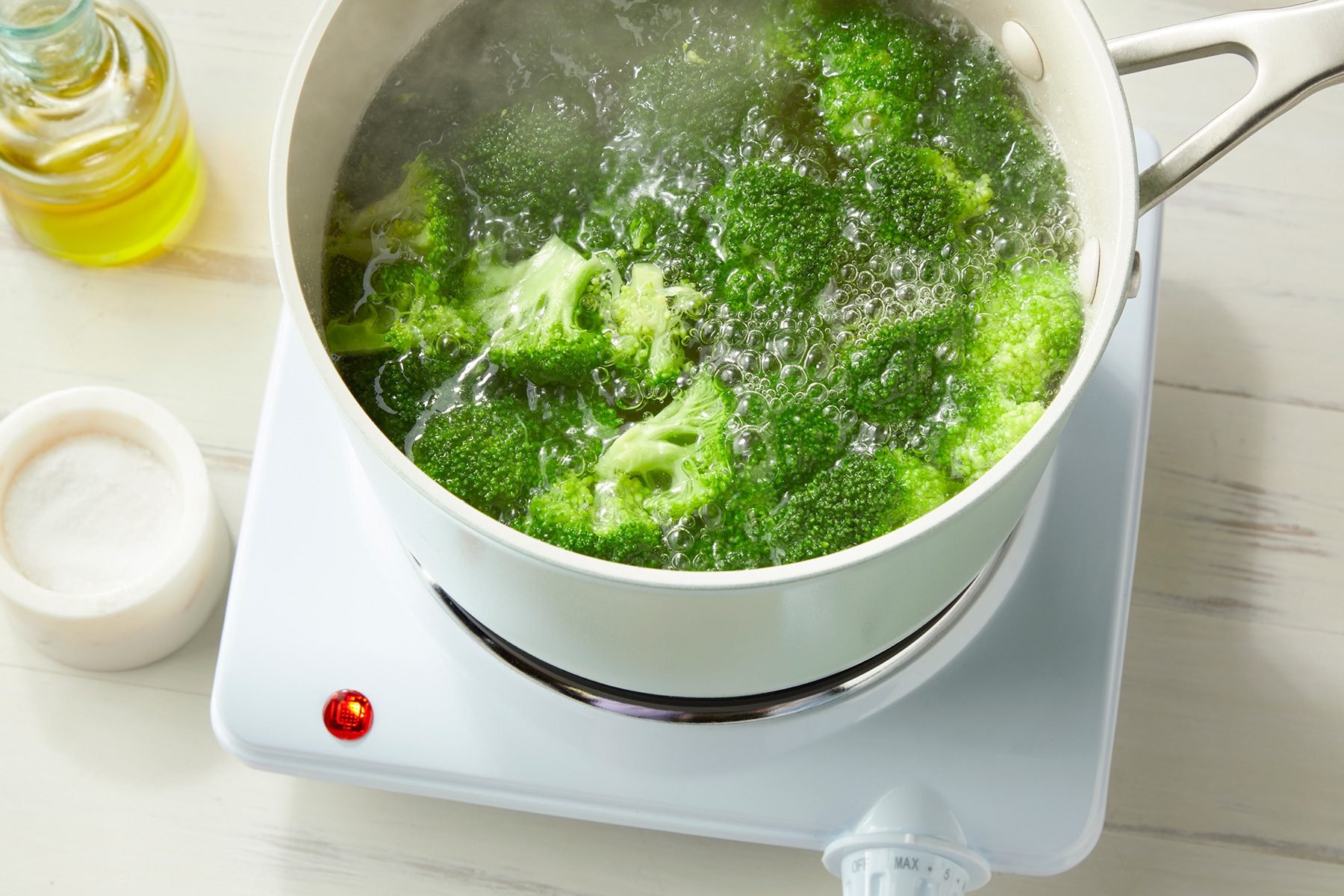 overhead shot; white background; boiling Broccoli in a saucepan;