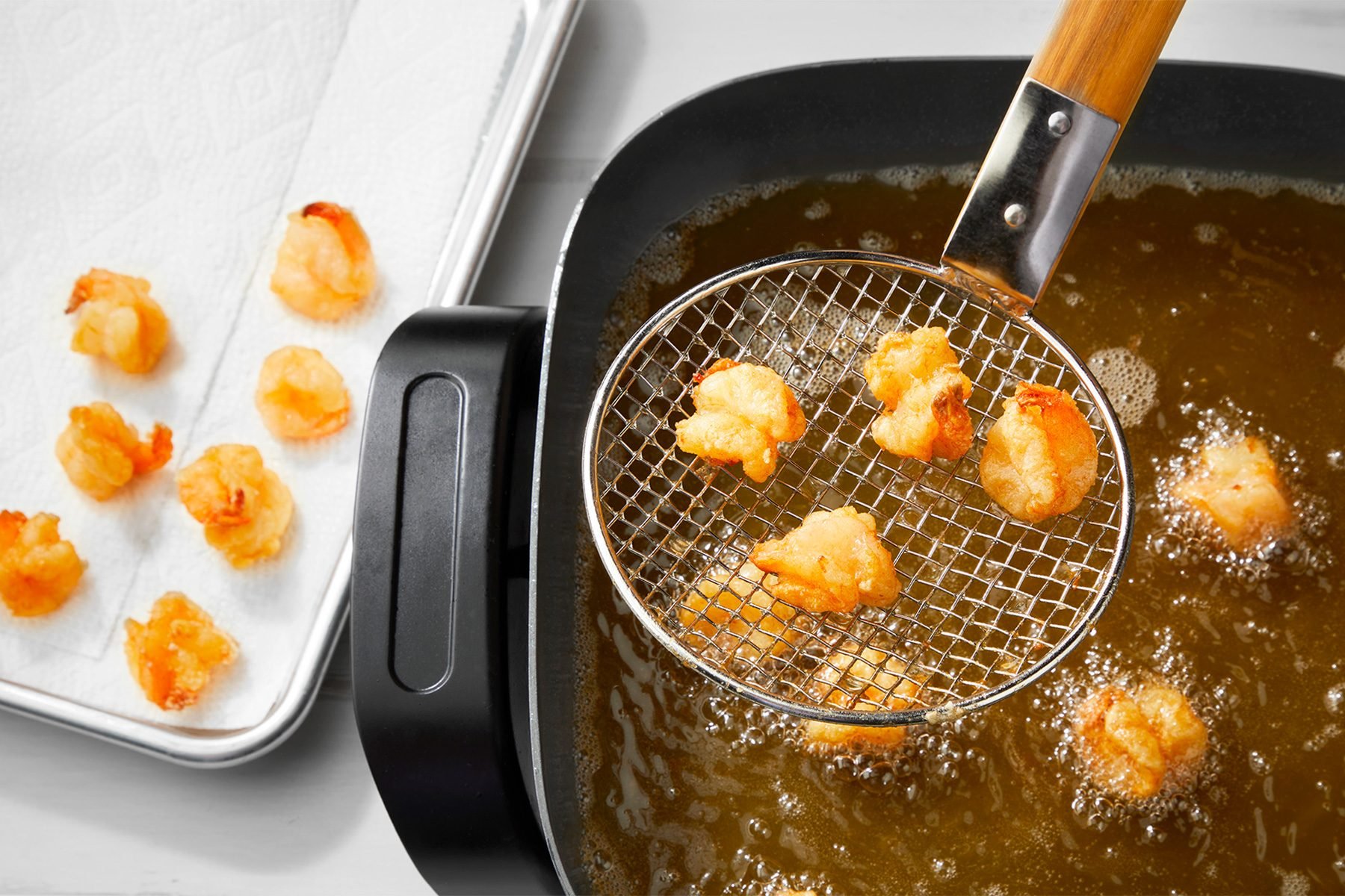 3/4th shot; white background; Frying shrimps;